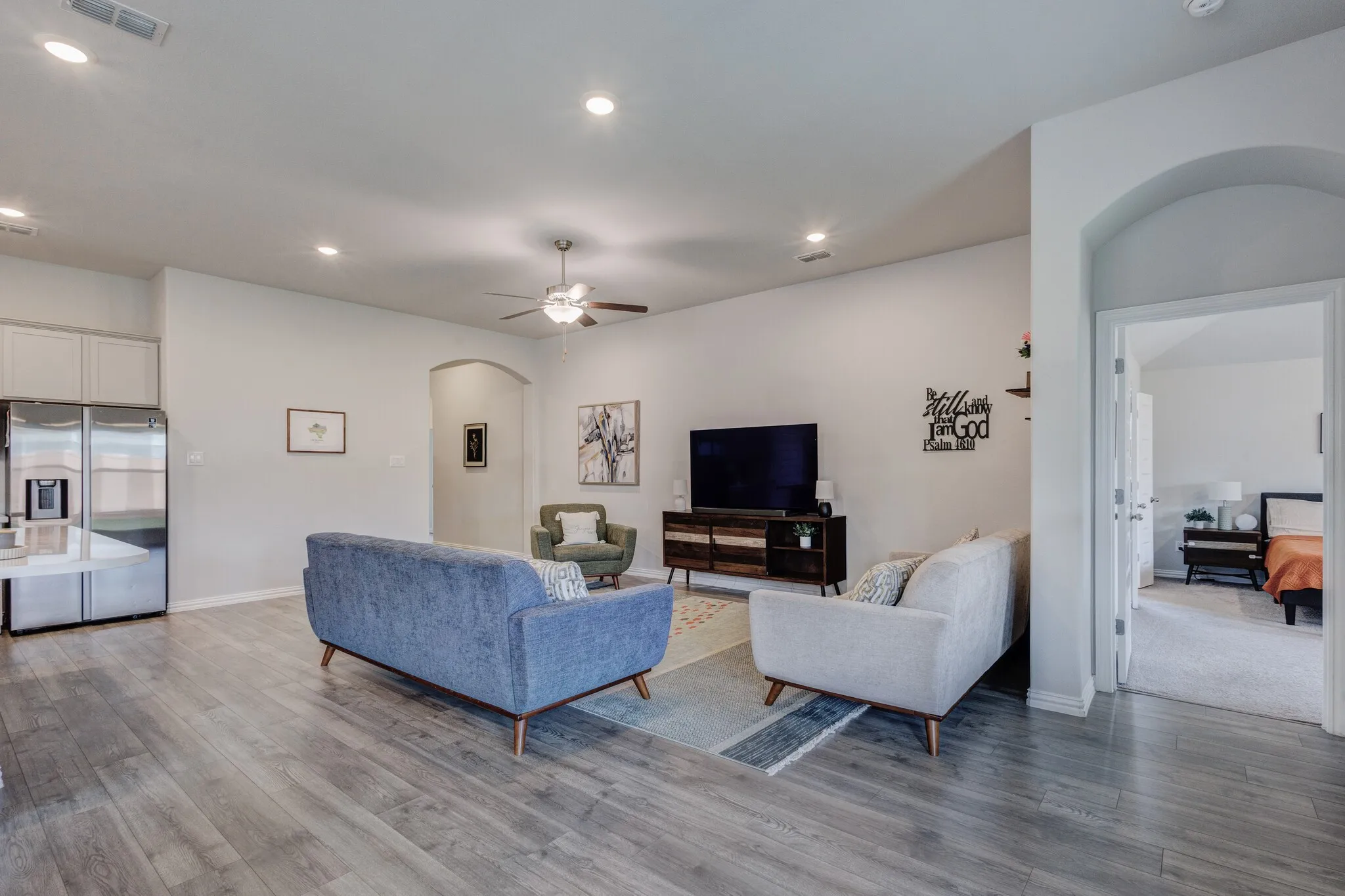 Spacious living area featuring wood-finish flooring, recessed lighting, and an arched doorway