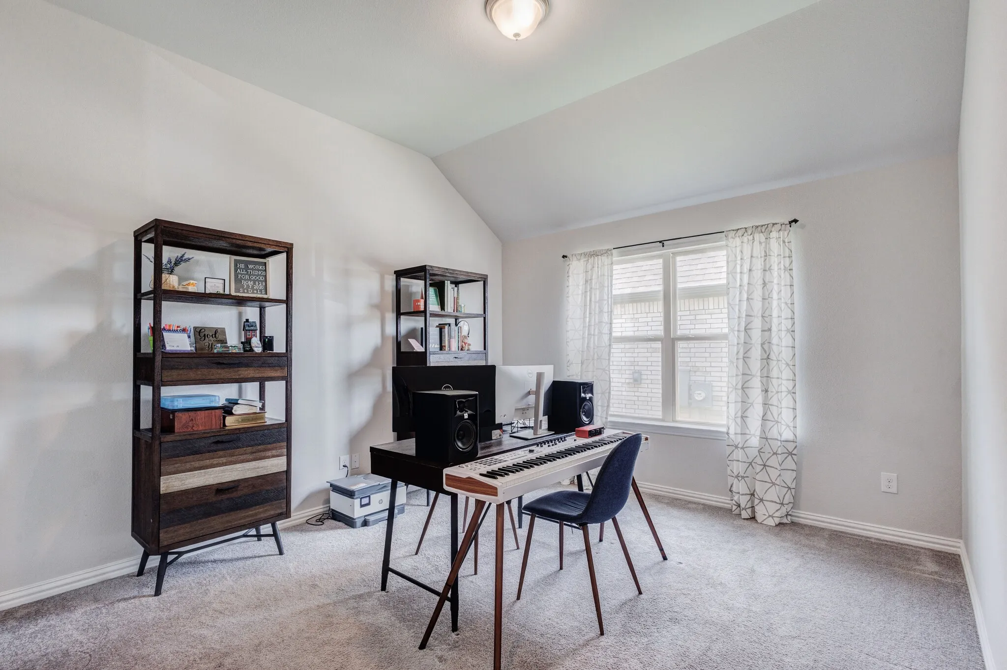Vaulted ceiling with a flush-mount light fixture, white walls, double-pane window, and carpet flooring