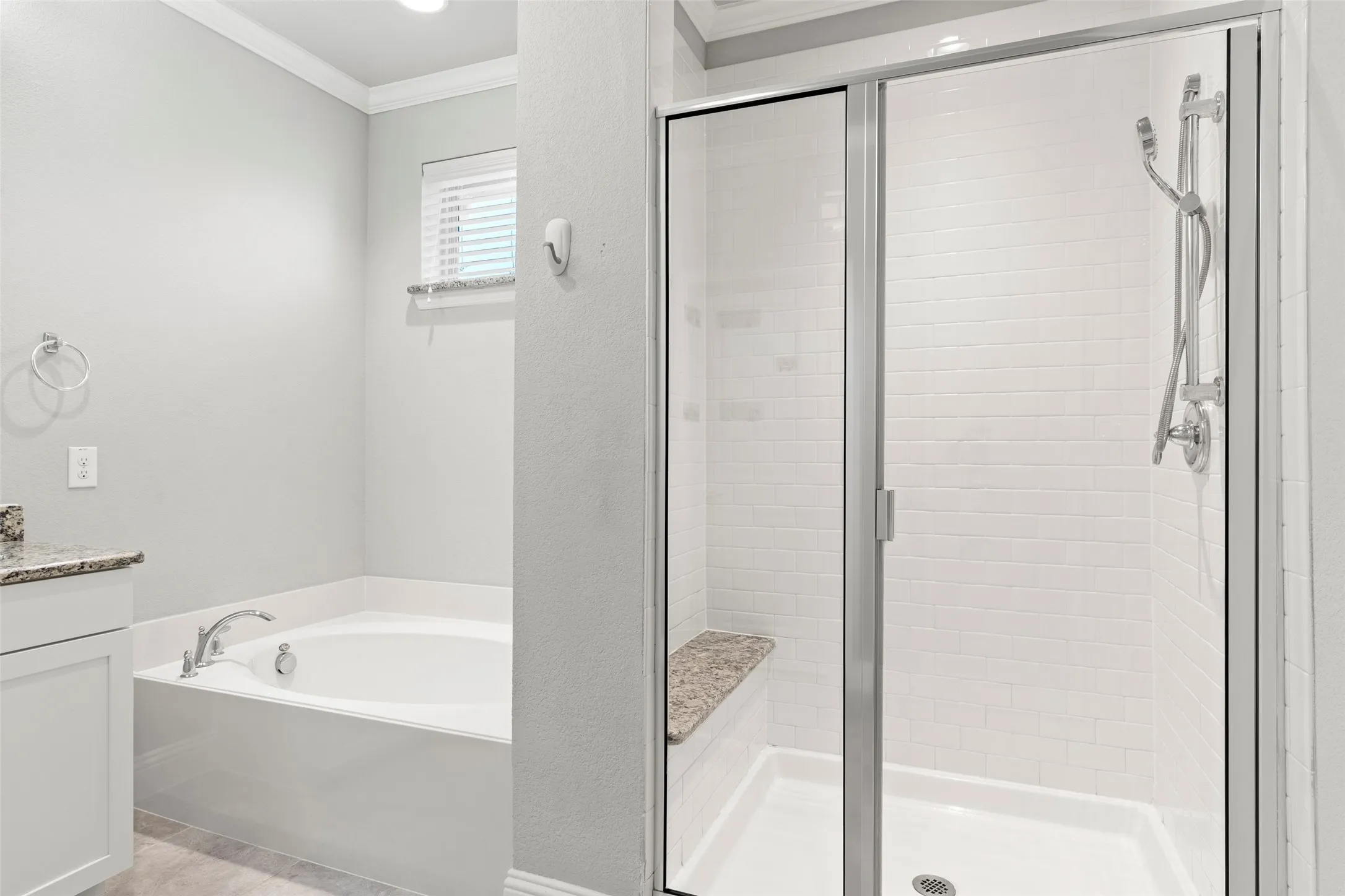 Spa-inspired primary bathroom featuring a soaking tub with chrome fixtures, a spacious walk-in shower enclosure with frameless glass doors and subway tile surround, light wood-finish flooring, and soft recessed ceiling lighting
