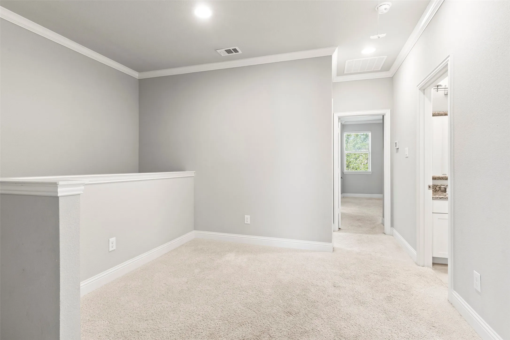 Carpeted loft area with recessed lighting, crown molding, and white trim