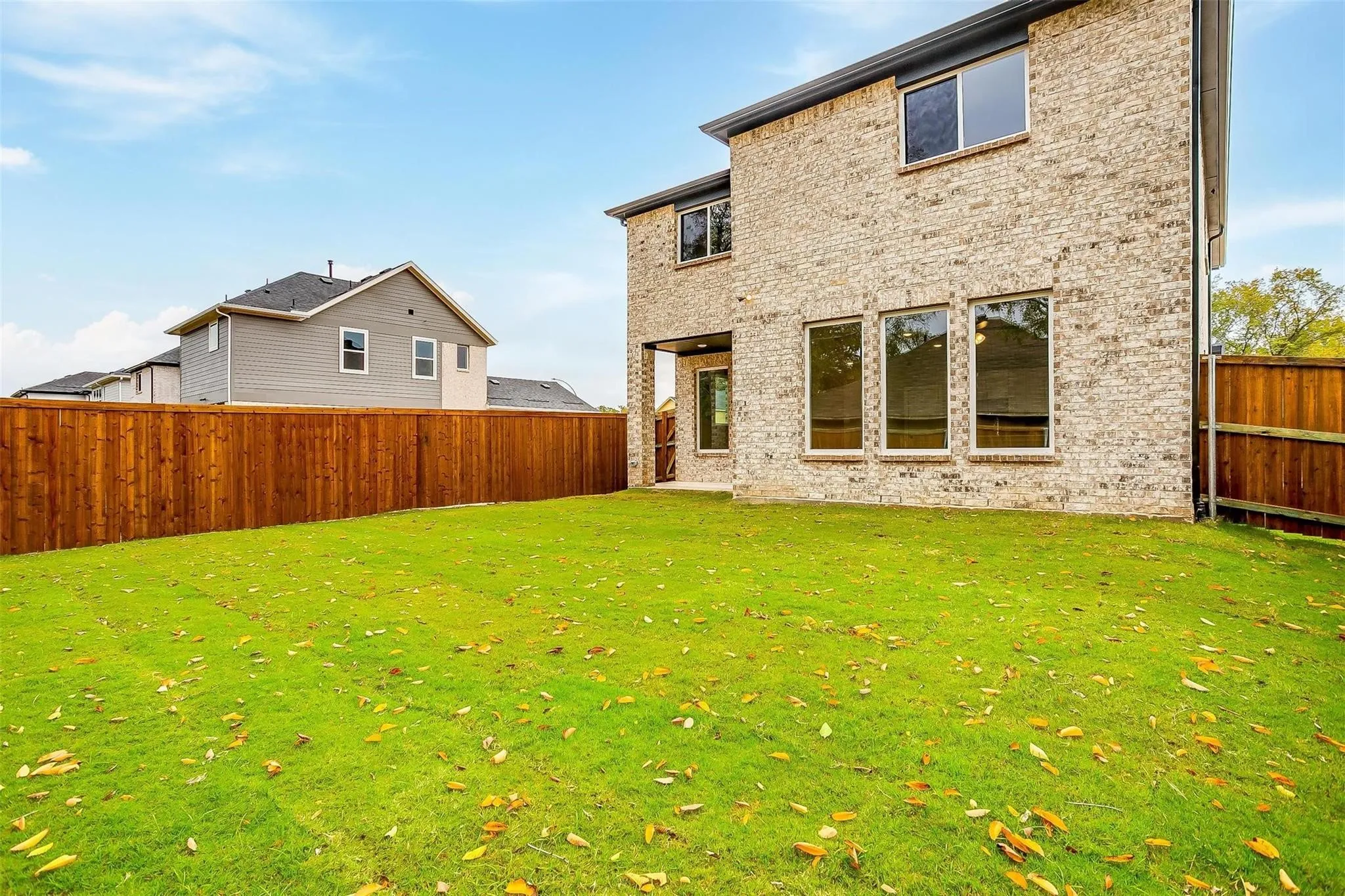 Expansive green lawn with a wood privacy fence