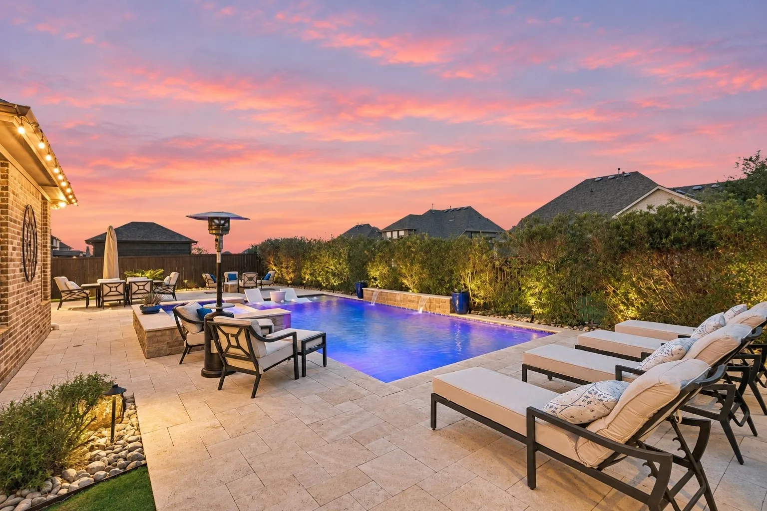 Luxury Pool And Spa With Water Features, Travertine Decking, And Fire Pit