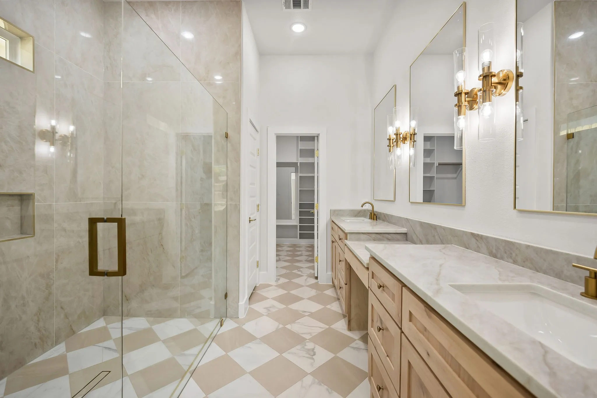 Expansive dual vanity with integrated sinks, stone countertops, and gold-finish fixtures