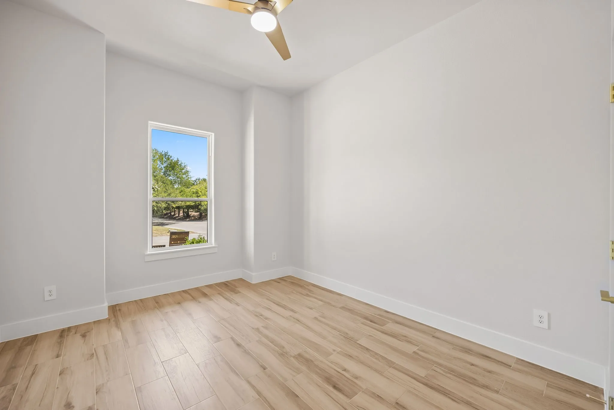 Recessed window featuring a wood-finish floor and a ceiling fan