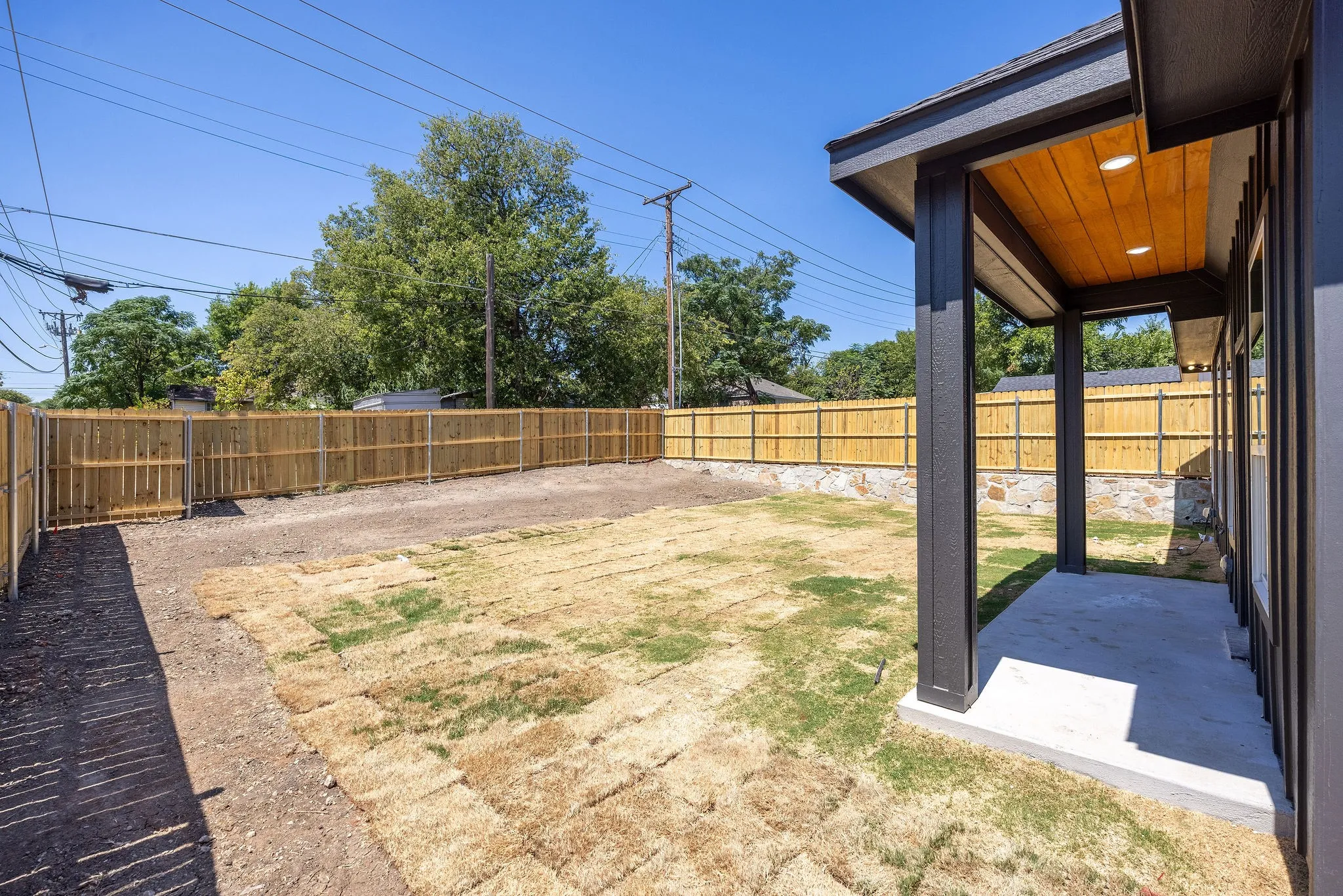 Covered patio with a wood-finish ceiling, integrated lighting, and a concrete slab