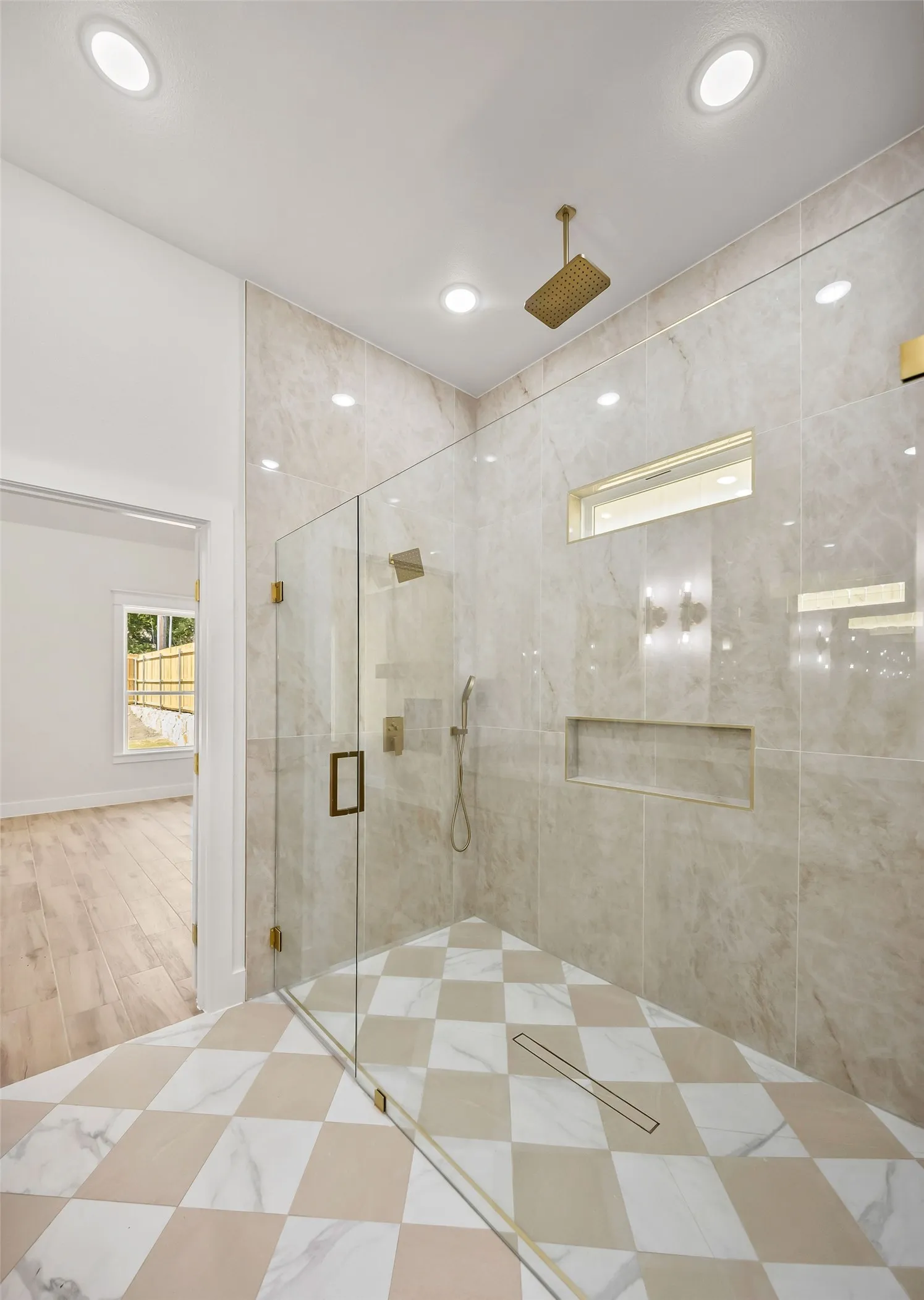 Walk-in shower featuring a glass enclosure, checkered tile flooring, and integrated wall niche