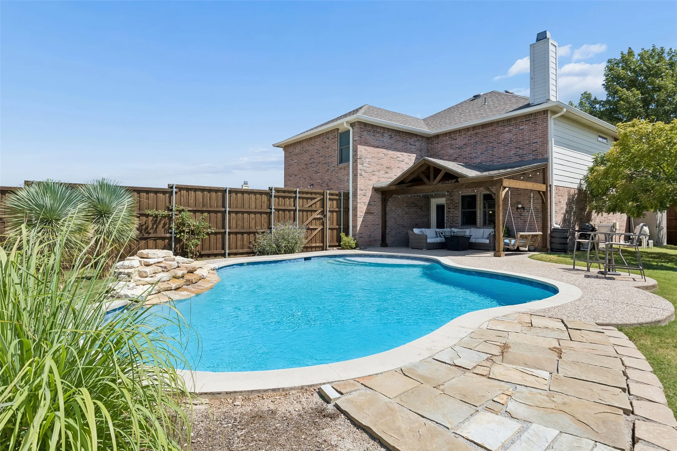 Poolside Living with Room to Gather – The resurfaced swimming pool is surrounded by a cool-deck area that provides space for seating and outdoor entertaining, with the covered patio positioned just steps away.