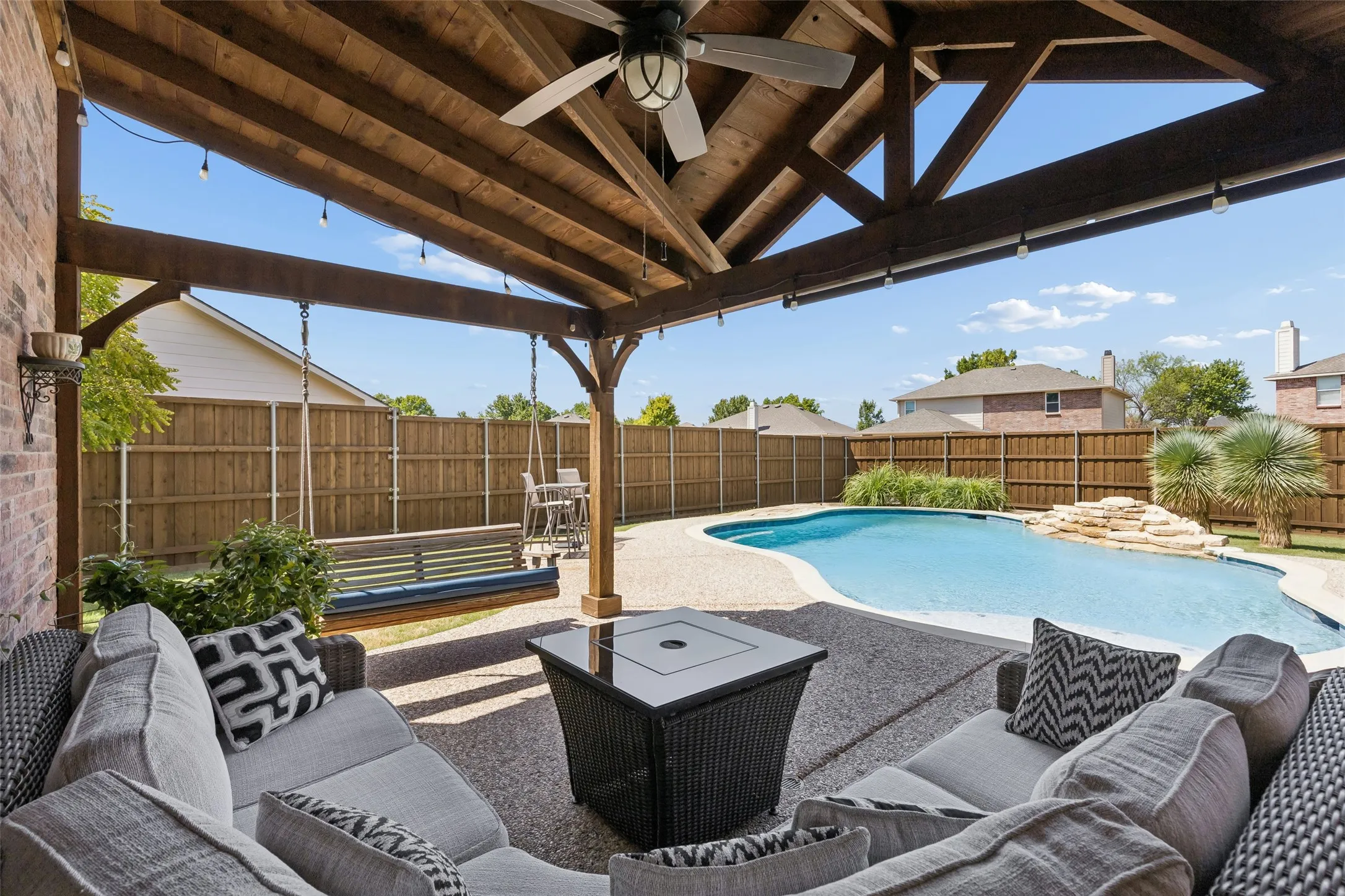 A Shaded Extension of the Living Space – The approximately 18-by-11-foot cedar-covered patio creates a comfortable place to relax outdoors while overlooking the pool and backyard.