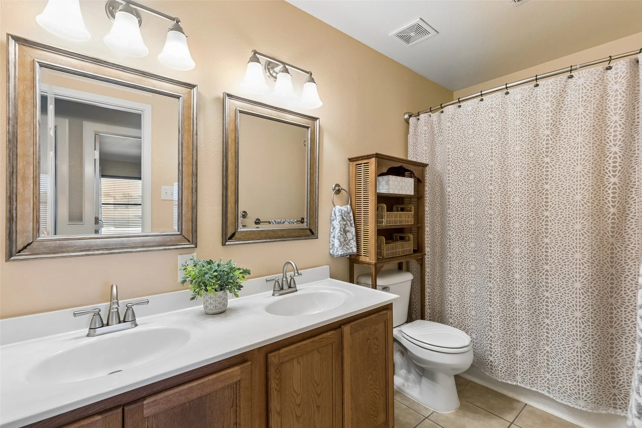 A Practical Second Full Bath – A long vanity with two sinks provides useful counter space, while the tub-and-shower combination keeps the layout efficient and functional for everyday use.