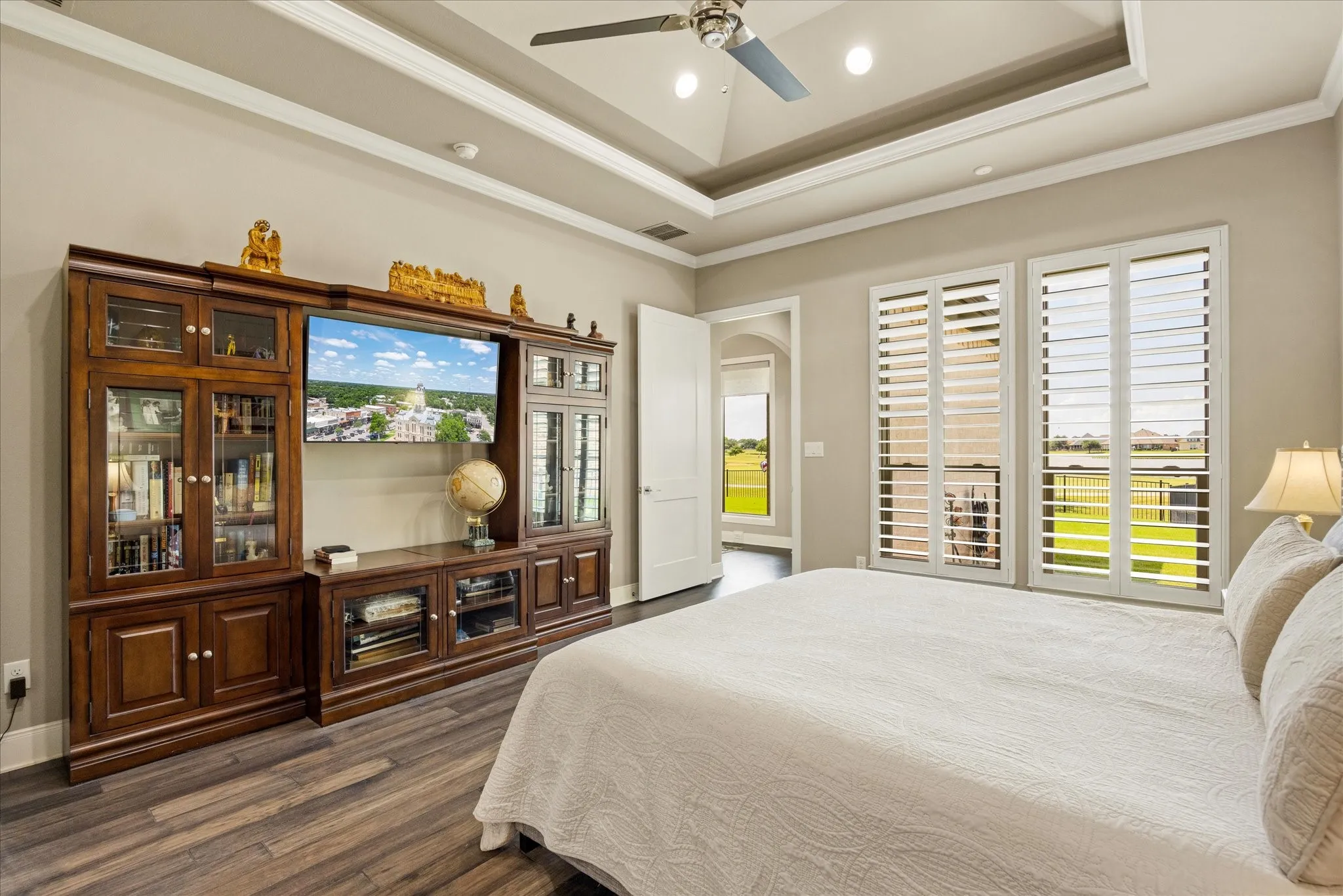 The primary suite is a serene retreat featuring expansive views and an elegant lighted tray ceiling that adds architectural interest and ambiance.