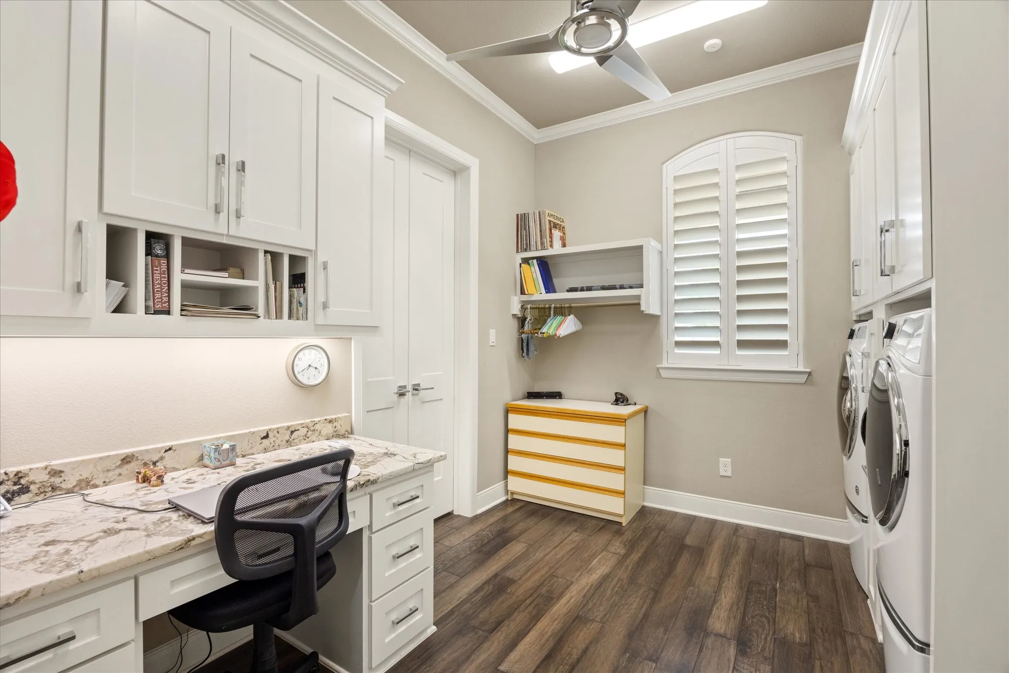 Conveniently located just off the primary suite, the spacious laundry room offers abundant built-in storage and a dedicated desk/work area for added functionality.
