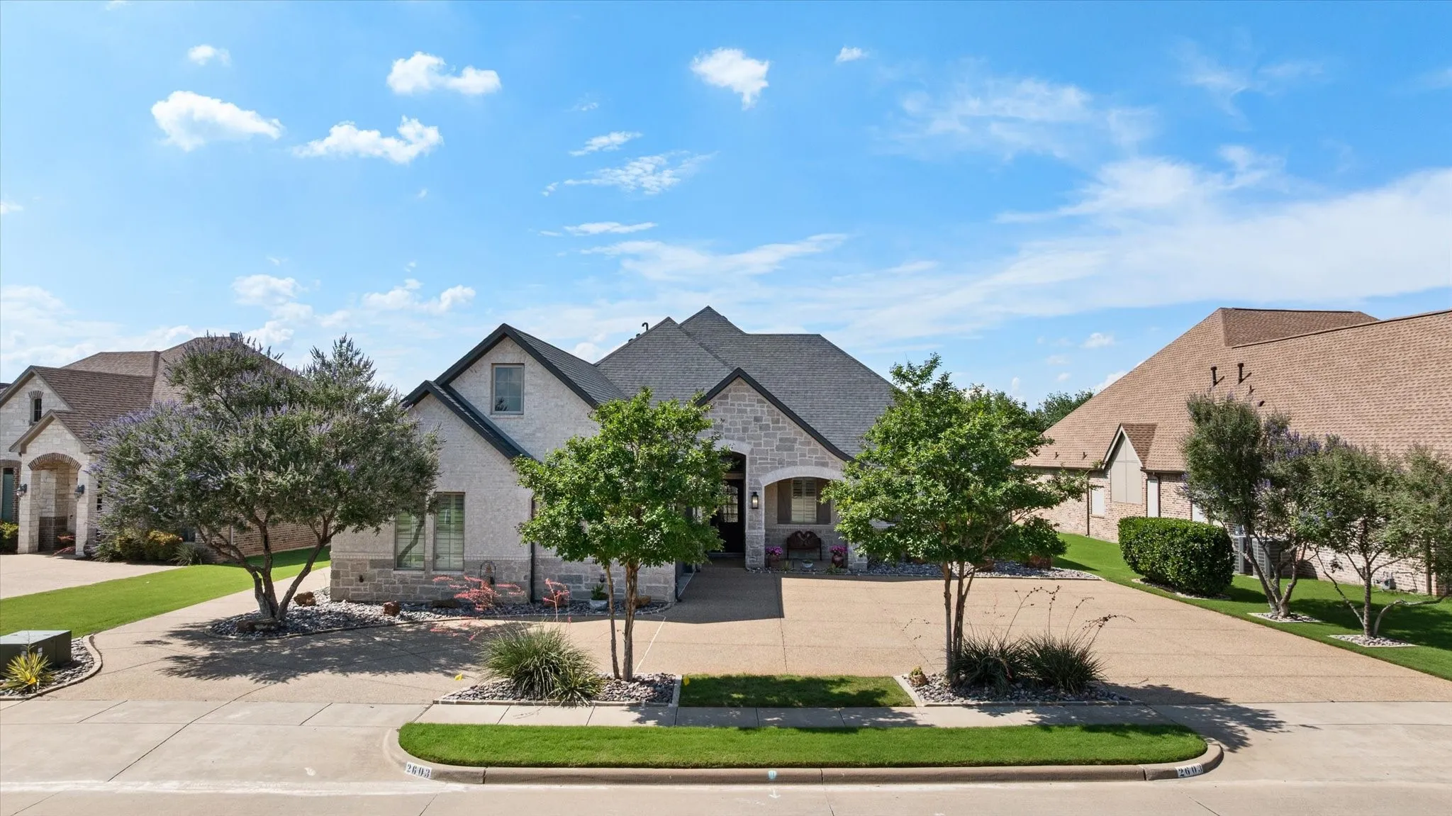Beautifully designed xeriscape landscaping enhances the home’s architectural character while providing a sophisticated, low-maintenance front landscape.