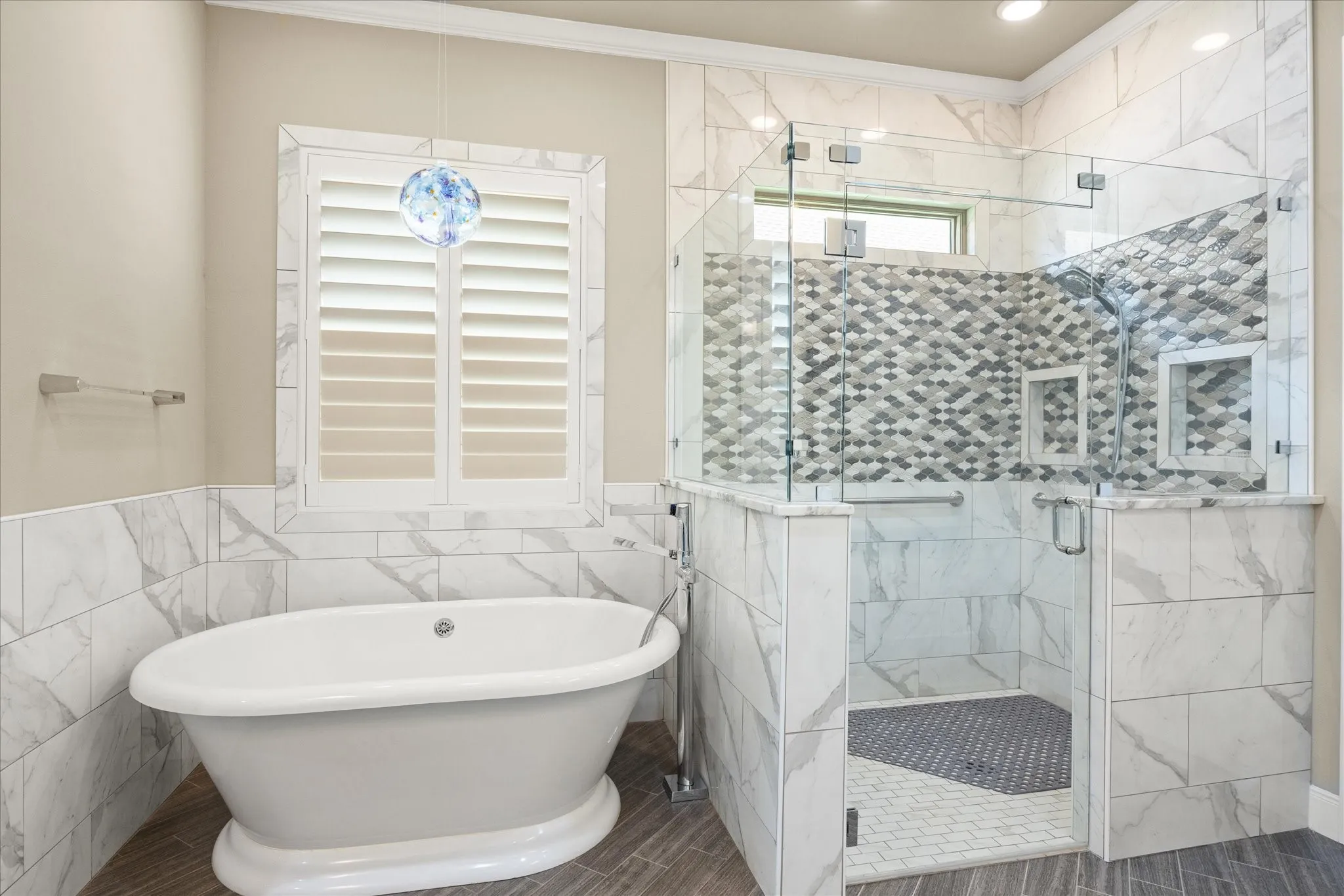 Luxurious primary ensuite bath features an elegant soaking tub and generous walk-in shower, enhanced by transom windows that bring in beautiful natural light.