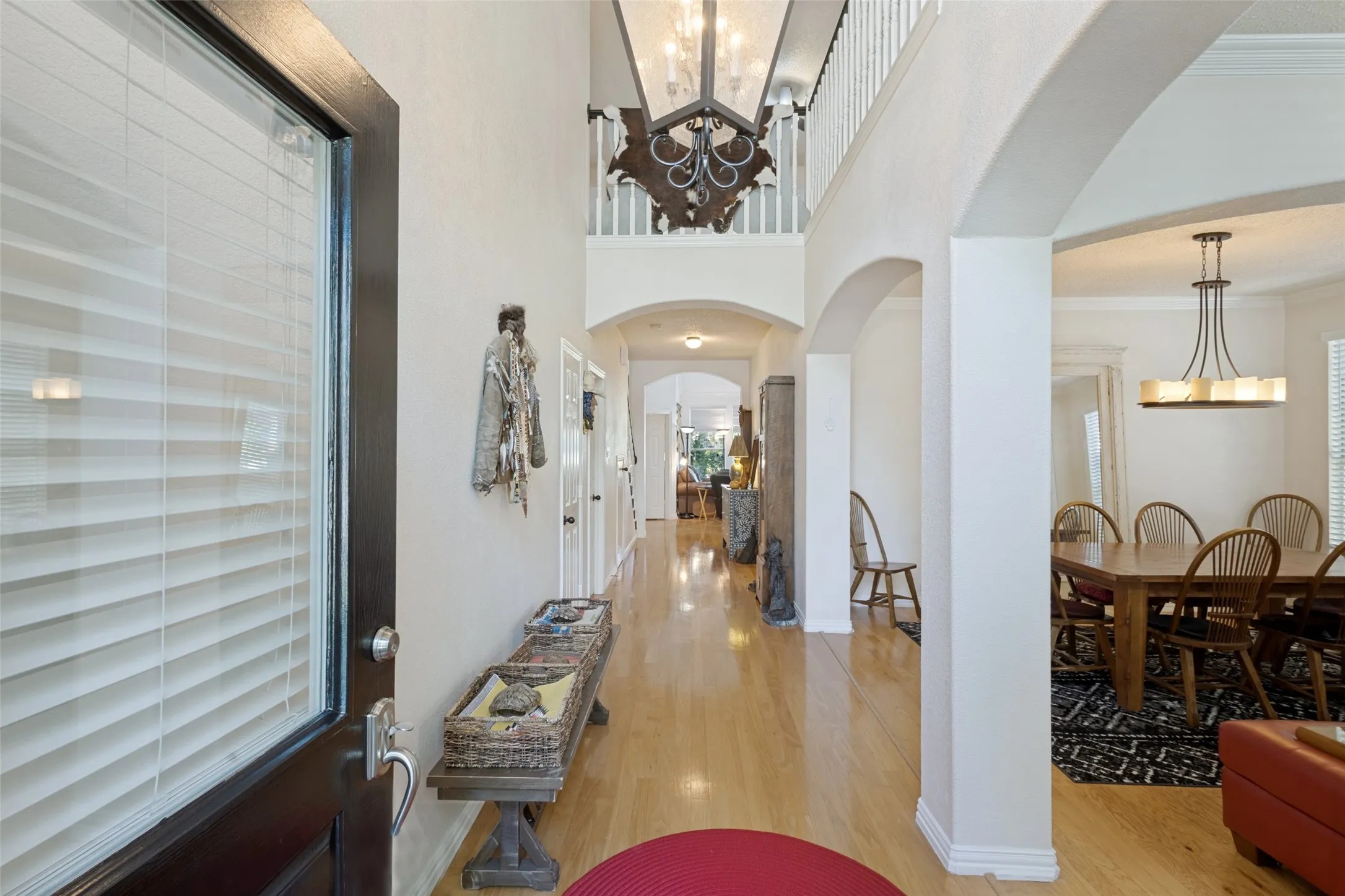 Dramatic foyer is “Gallery-style” with trending light hardwoods throughout all the downstairs living areas, walkways & primary bedroom!