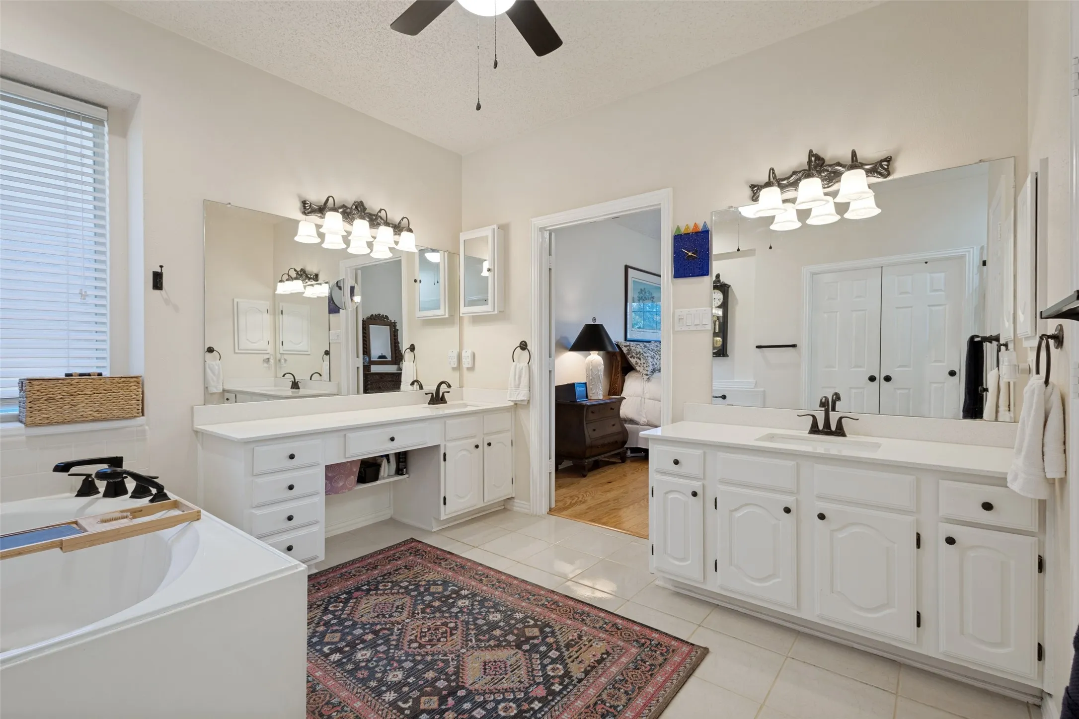 The remodeled Primary Bath is spa-like with marble counter tops, tile covered shower & romantic corner tub. Stylish updated lighting, hardware and high ceilings.