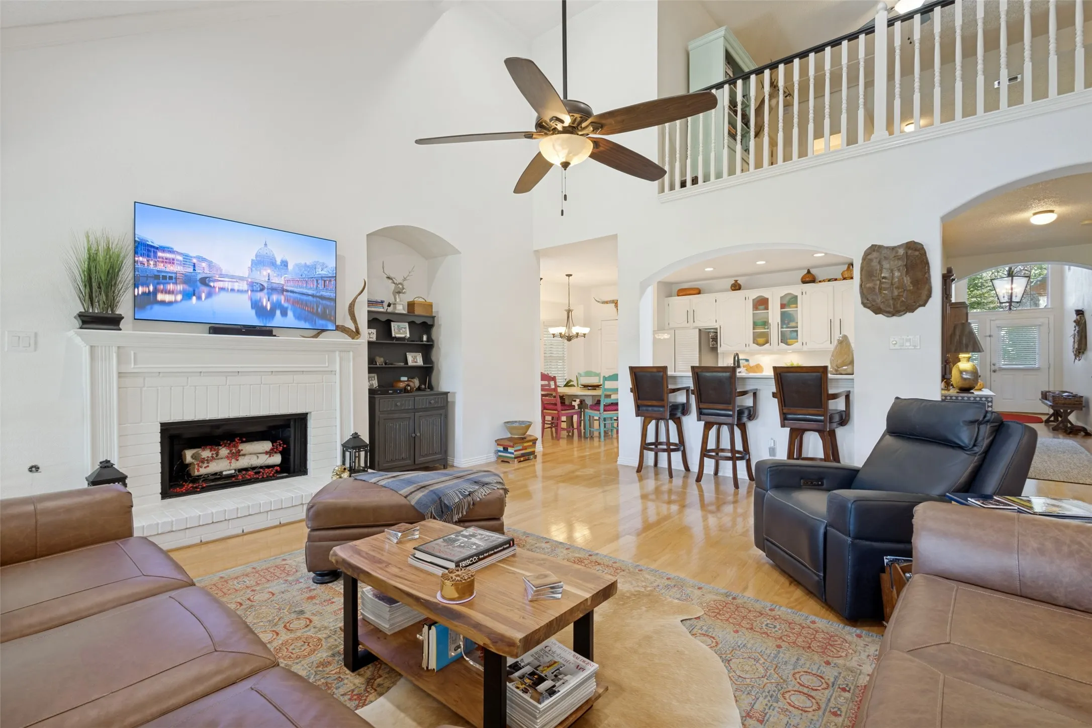 A spacious family room has tall panel windows and a mantled corner fireplace.

