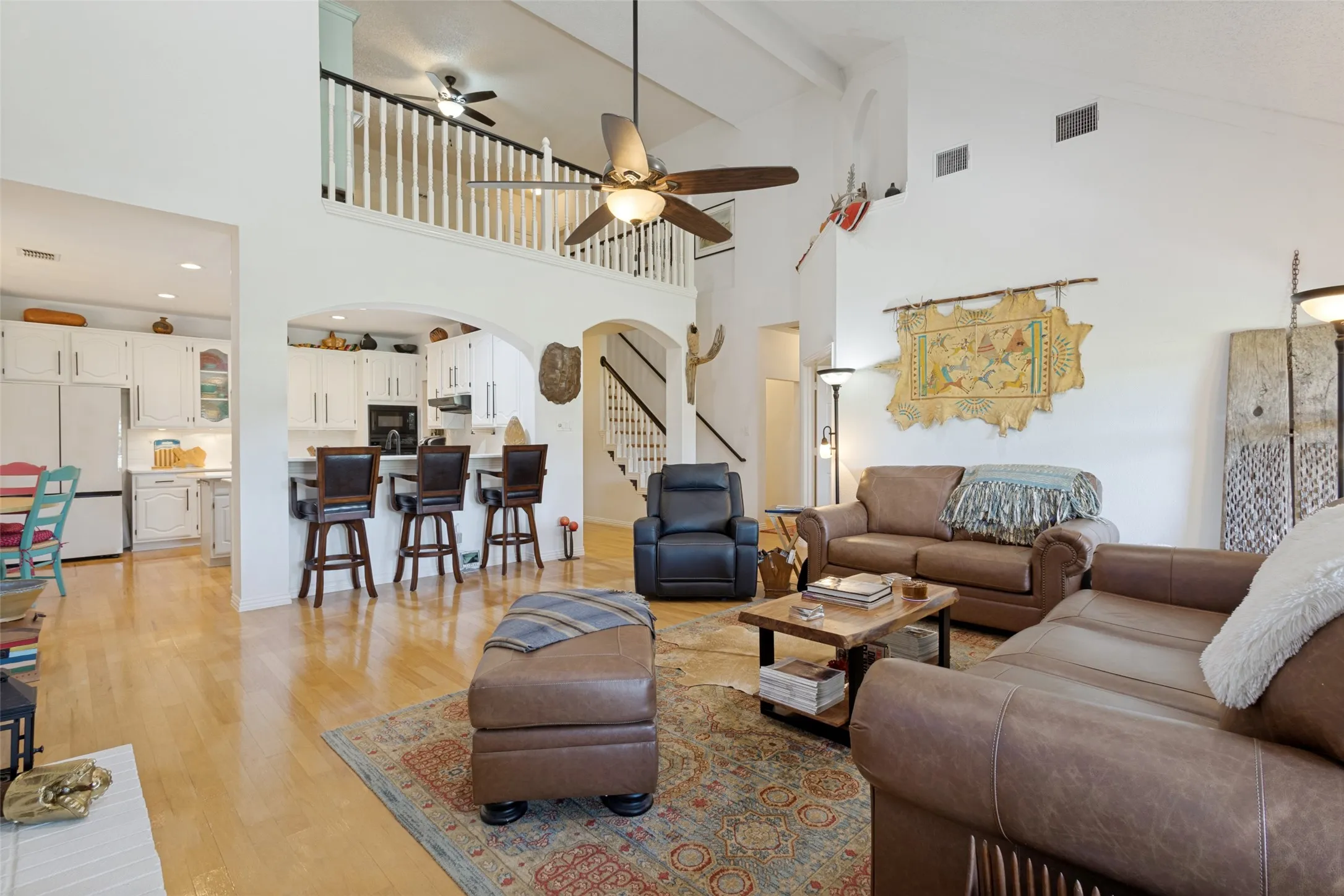 Open living with high two-story ceilings, hardwoods- this spacious family room is designed for entertaing. Open to the kitchen and has tall panel windows with patio and outdoor golf views.
