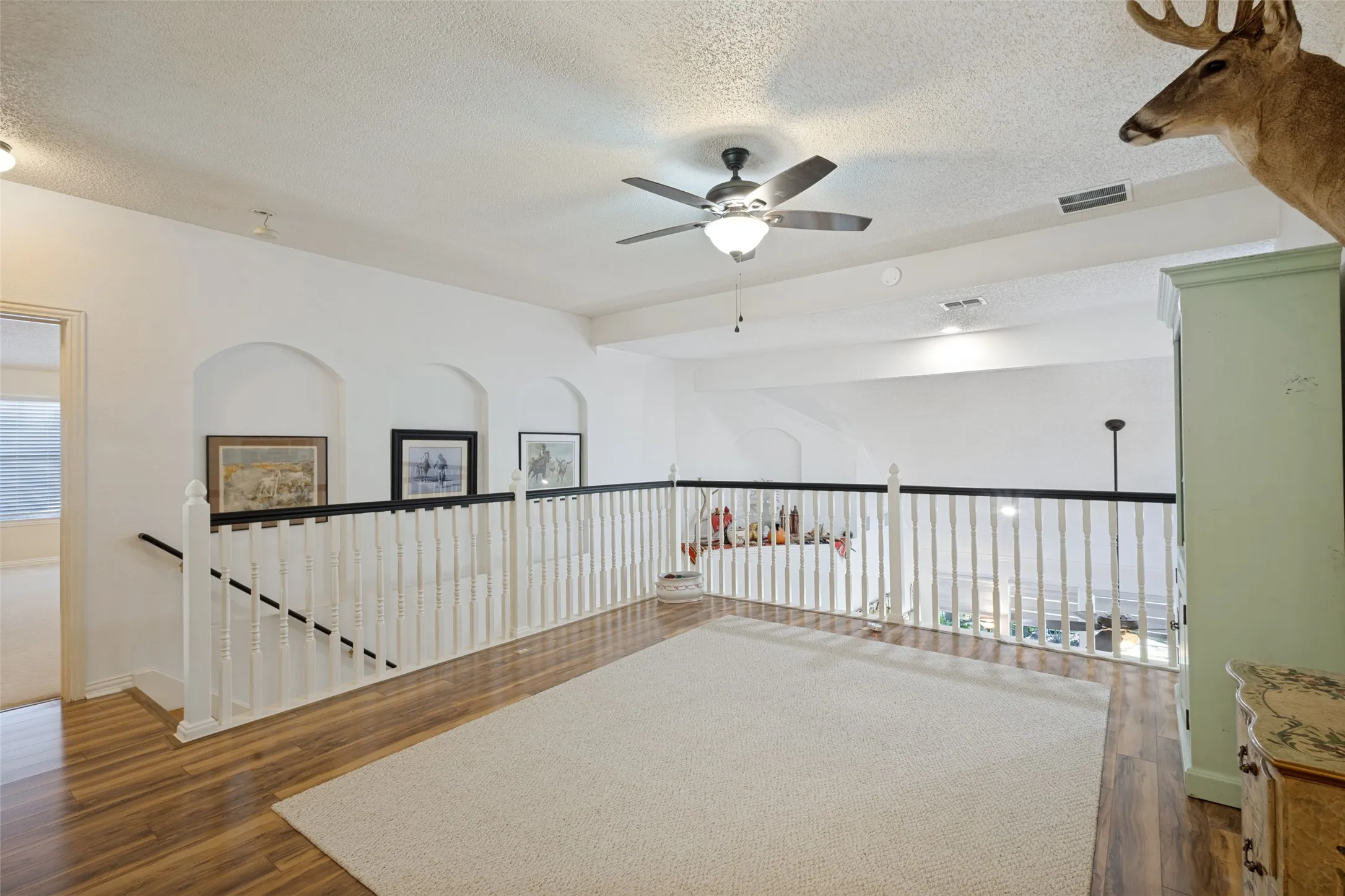 UPSTAIRS-  Art niches and shelves for displays. The staircase has hardwood steps leading up to a Living, Gameroom and two lovely split bedrooms.
