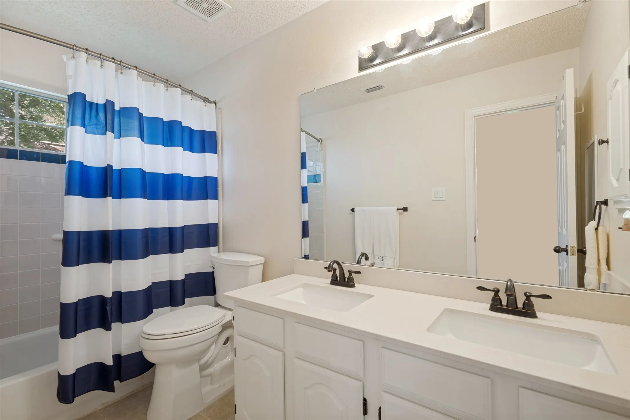 UPSTAIRS- Full bathroom has double sinks, full bathroom tub and shower enclosure.