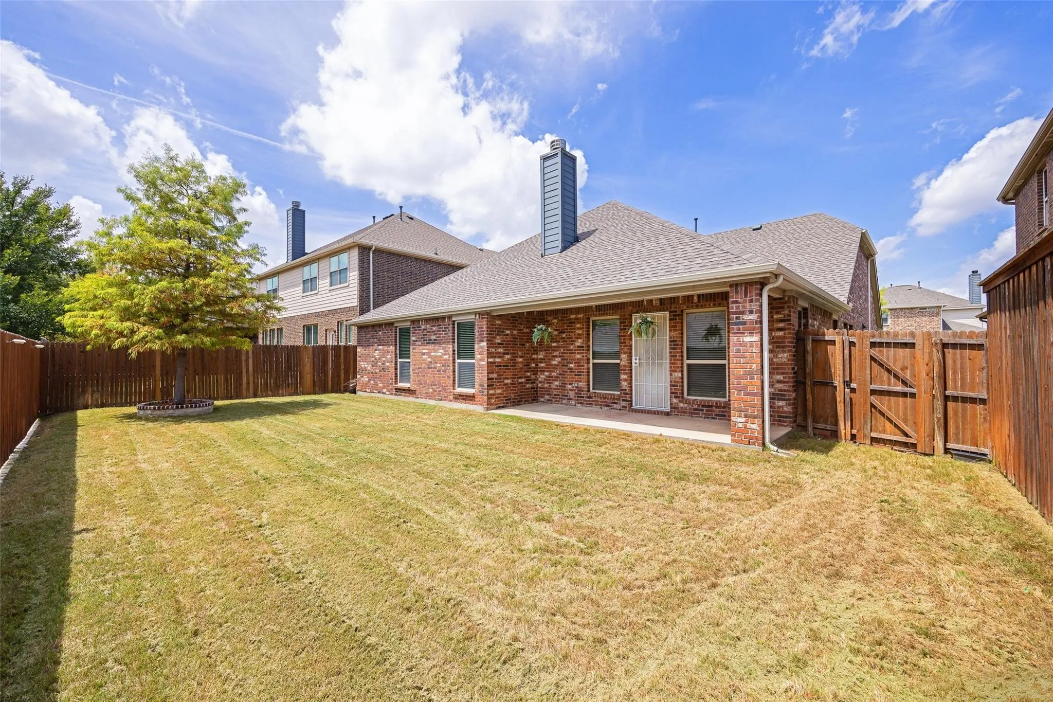 Rear view of house with a patio and a lawn