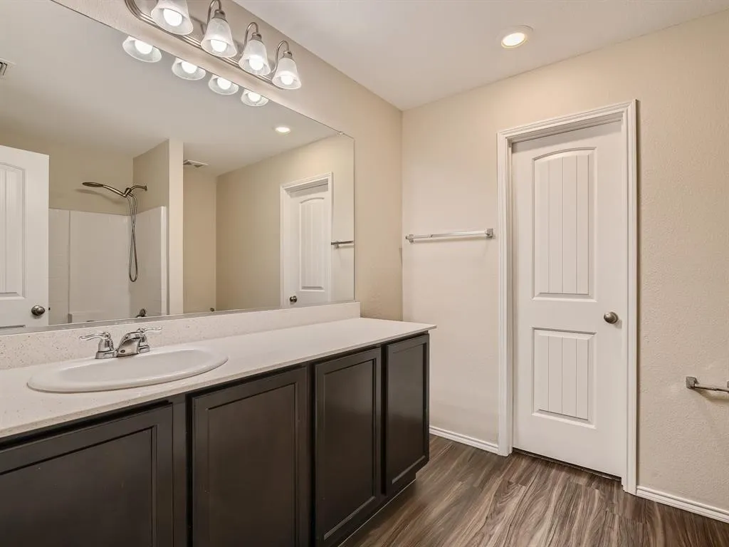 Expansive vanity with a single basin sink, generous countertop space, and dark wood-finish cabinetry