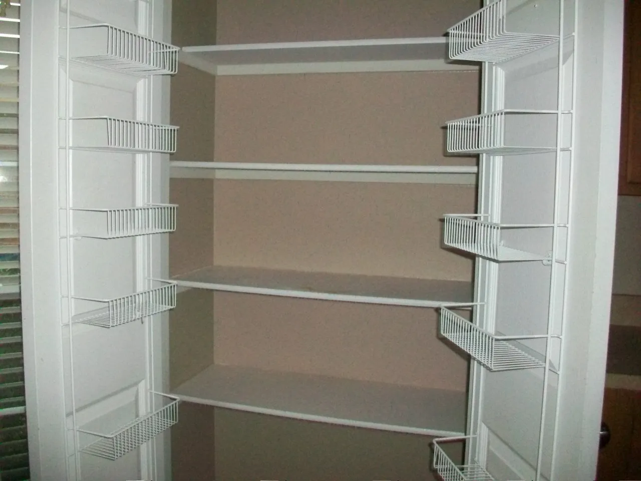 Pantry featuring multiple fixed shelves and door-mounted wire racks