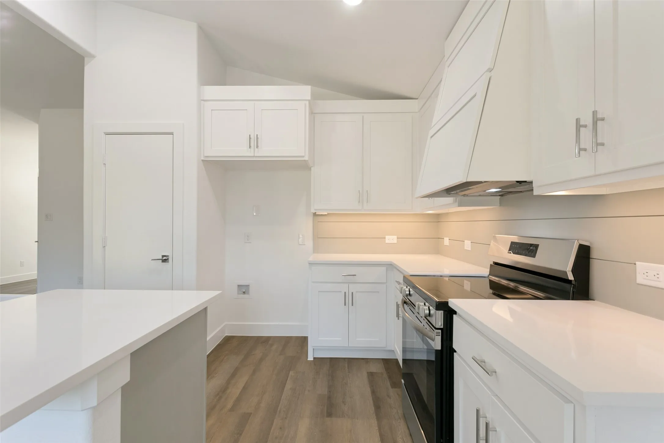 Modern kitchen featuring white shaker cabinetry, stainless steel range with matching hood, white countertops, wood-finish flooring, and recessed lighting