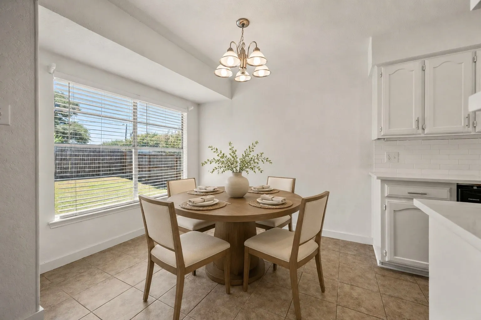 Dining area with a multi-pane window, tile flooring, and a multi-light chandelier
