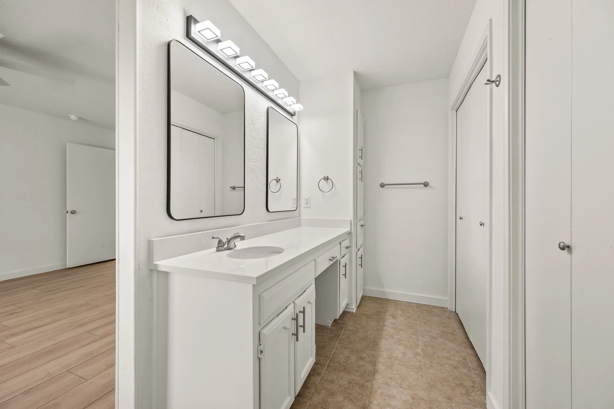 Double vanity with integrated sink, sleek mirrors, and contemporary lighting