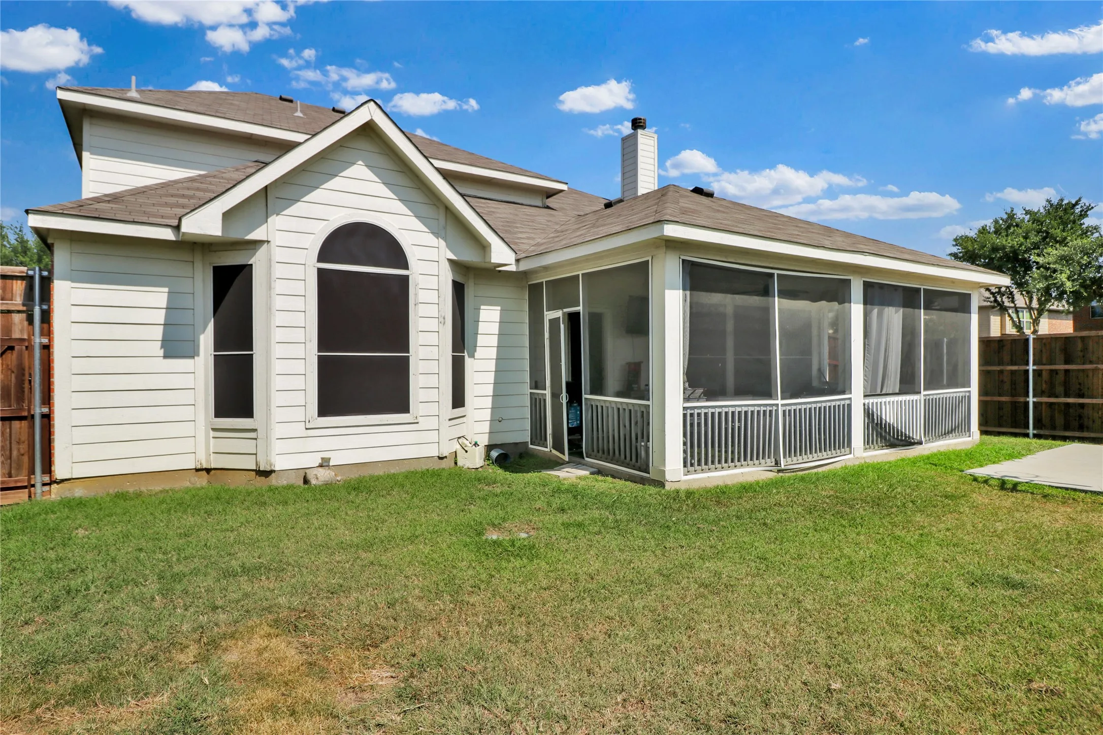 Back of home with screened in patio.
