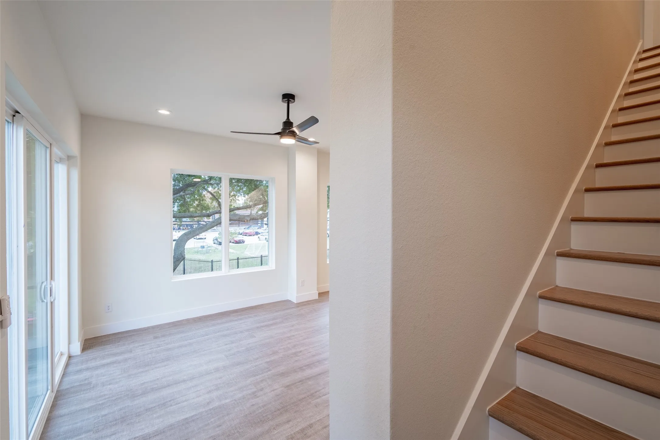 Stairs with ceiling fan and hardwood / wood-style floors
