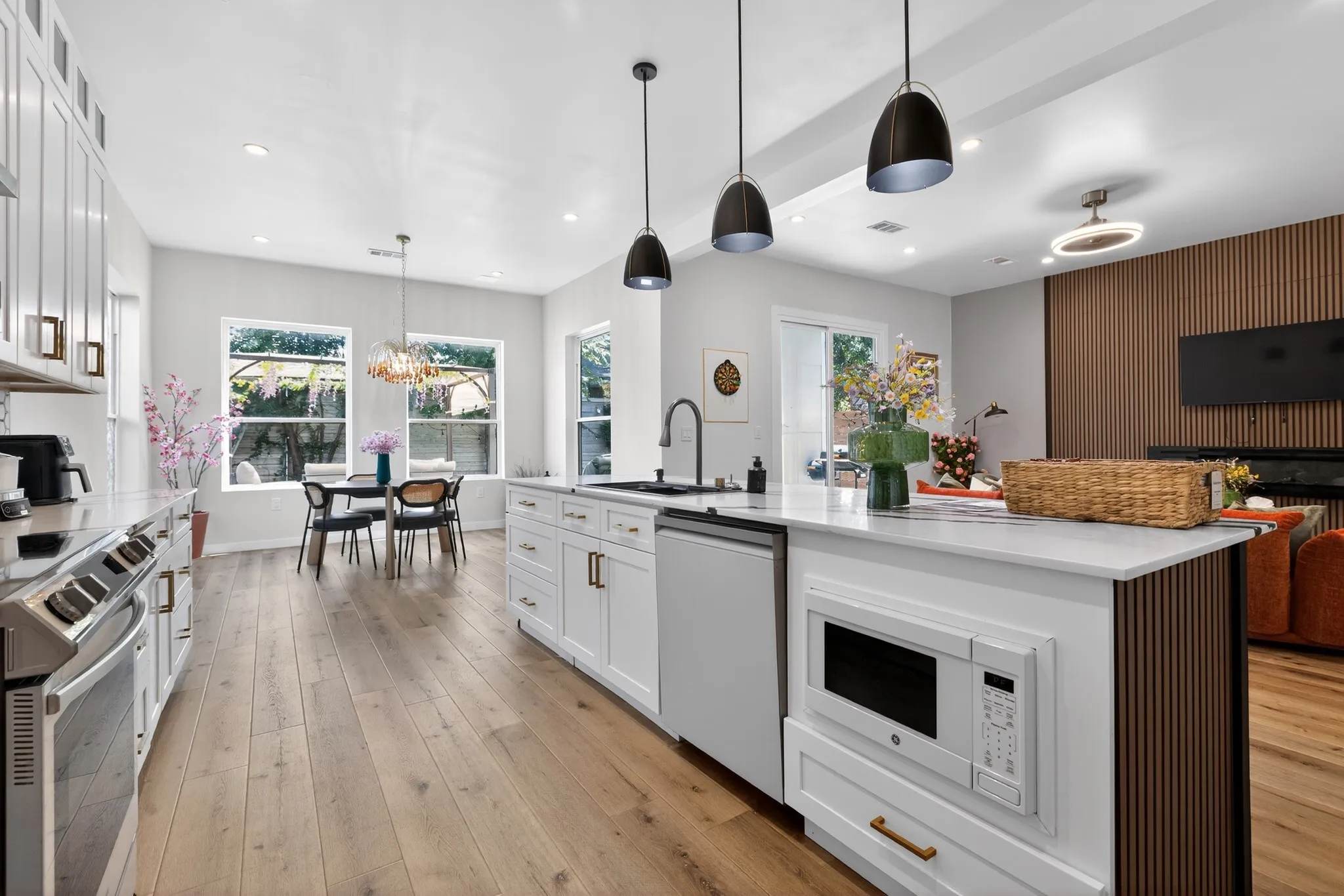 Contemporary kitchen featuring white cabinetry, a large center island with built-in microwave, wood-finish flooring, and recessed lighting