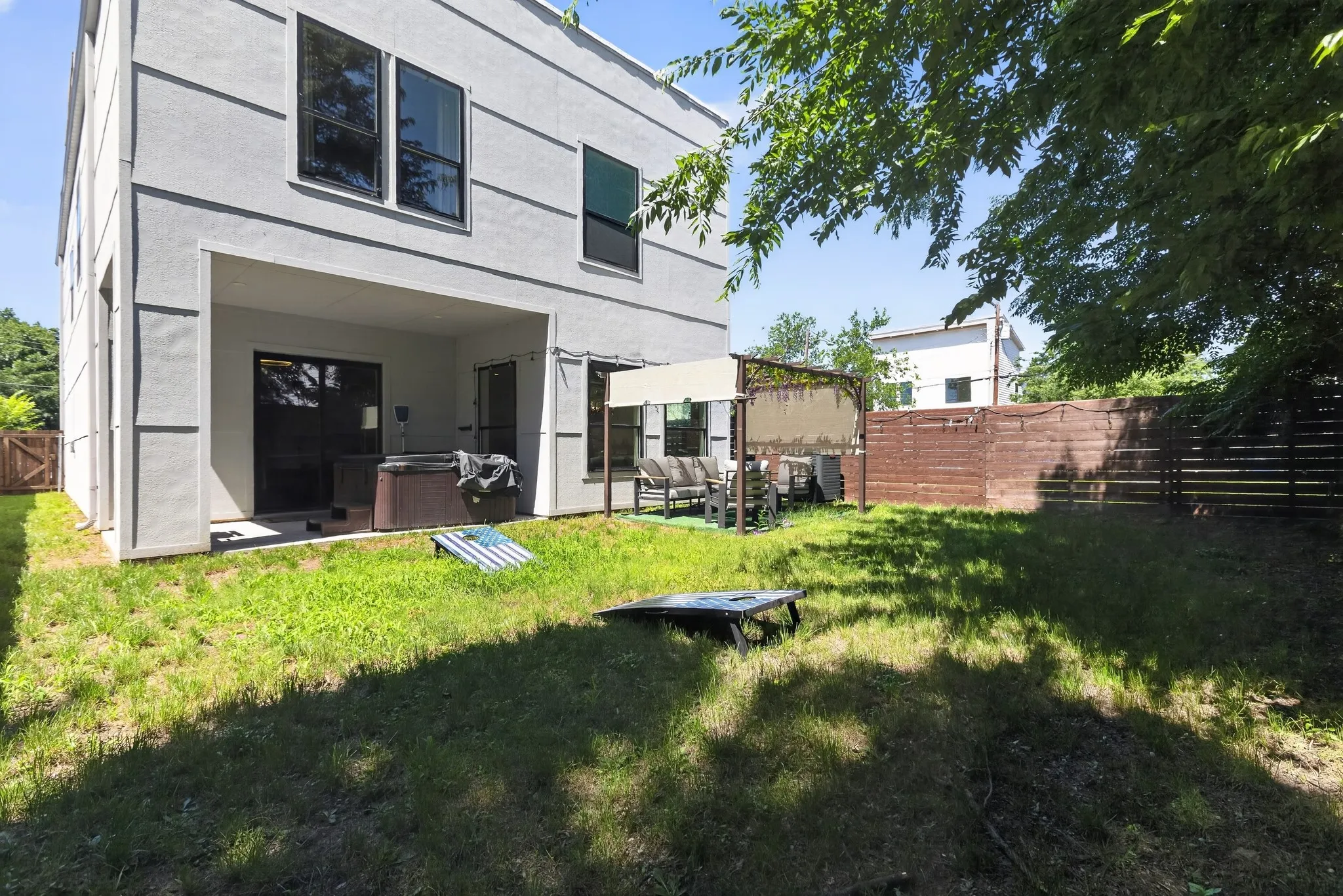 Rear exterior featuring a covered patio, concrete slab, and wood privacy fencing