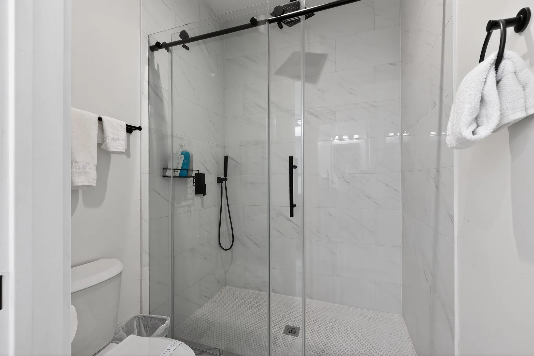 Walk-in shower with clear glass enclosure and black hardware