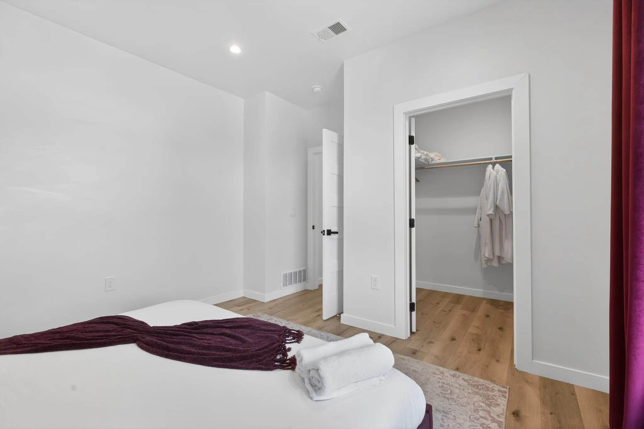 Wood-finish flooring, recessed lighting, and a closet with integrated shelving and hanging rod