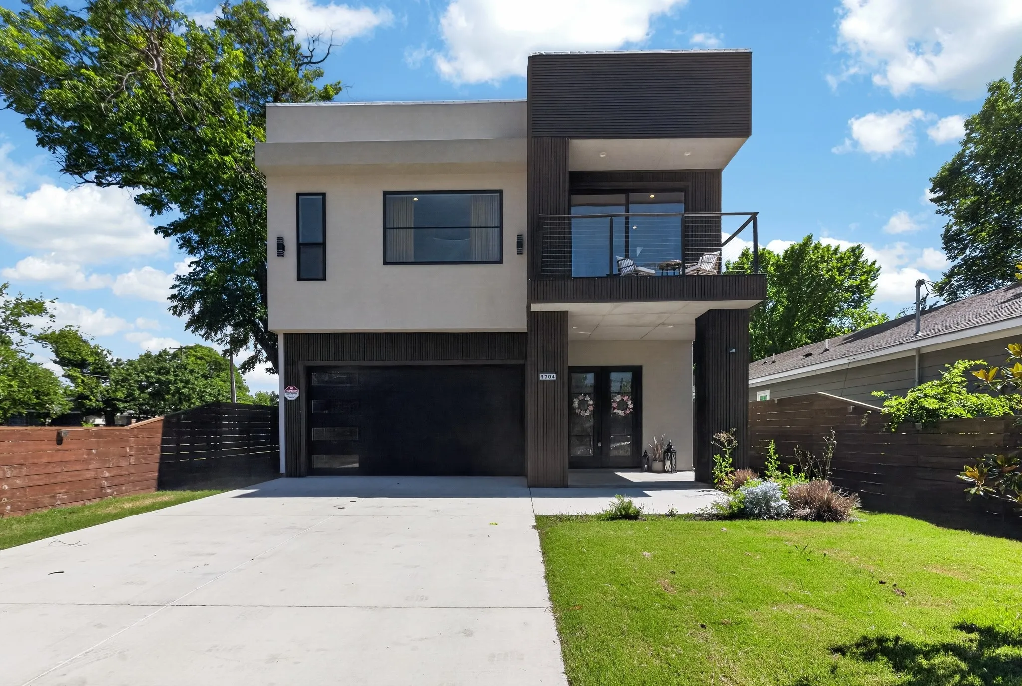 Modern two-story facade with clean lines and contrasting dark wood-look paneling
