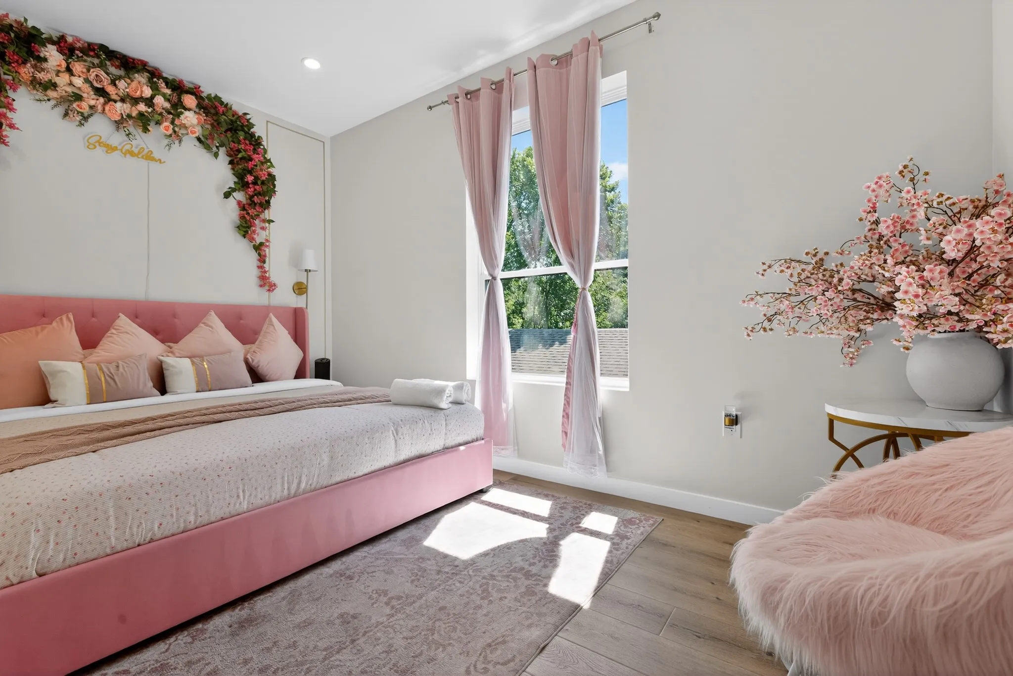 Recessed lighting, wood-finish flooring, and a large window with privacy drapes