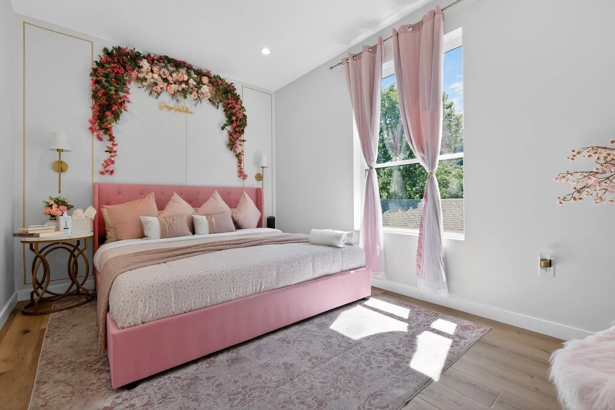 Recessed lighting, wood-finish flooring, and a large window with sheer drapes