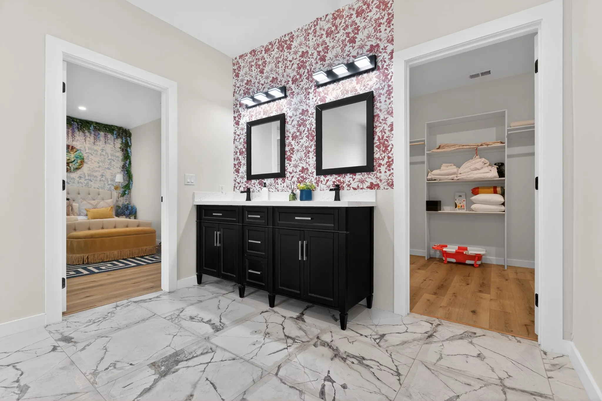 Dual sink vanity with black cabinetry, white countertops, and black framed mirrors