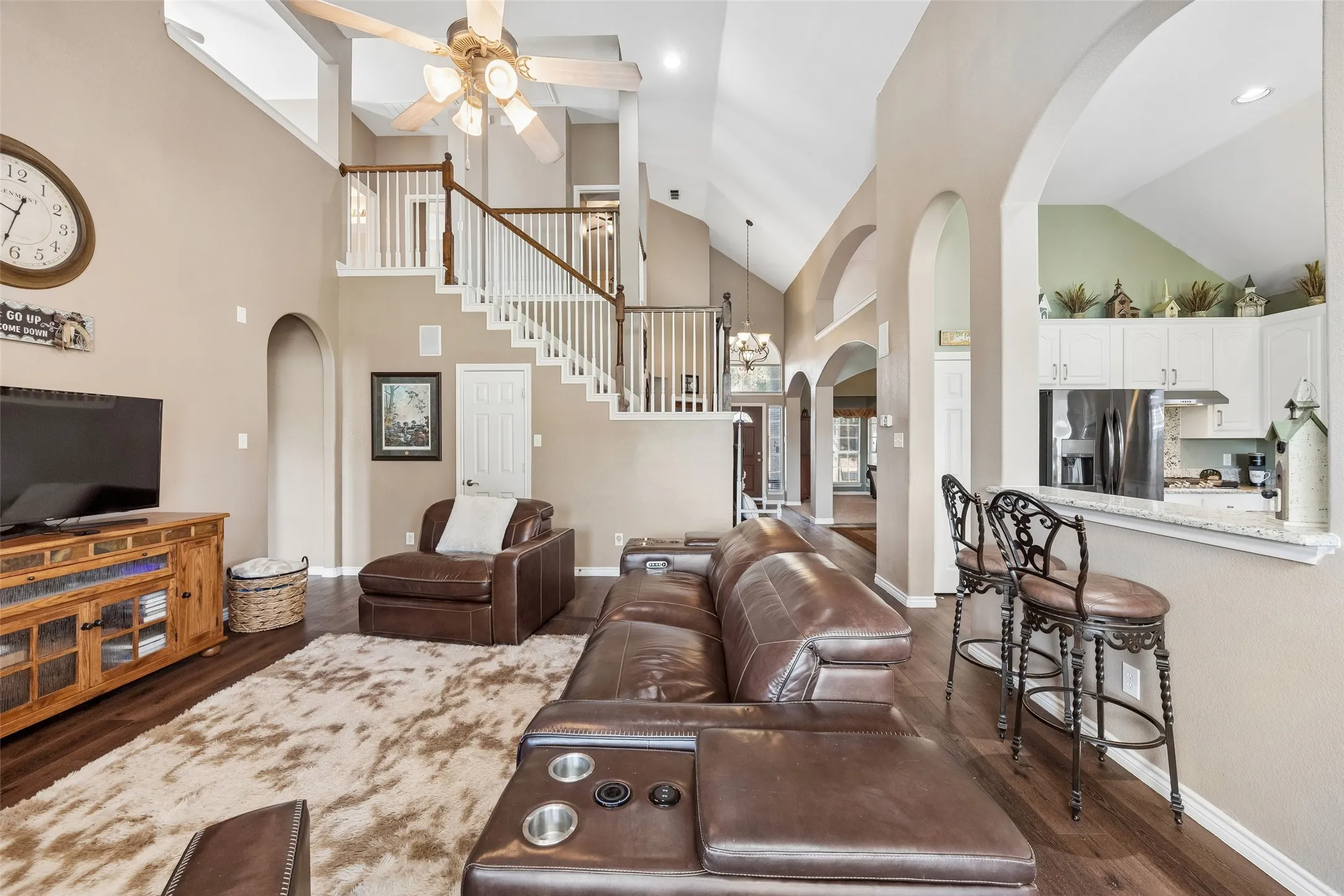 An Open Layout with Distinct Activity Zones — Tall arched openings separate the family room, kitchen, and breakfast area without closing them off from one another. The result is a layout where multiple spaces can function independently while still feeling connected.