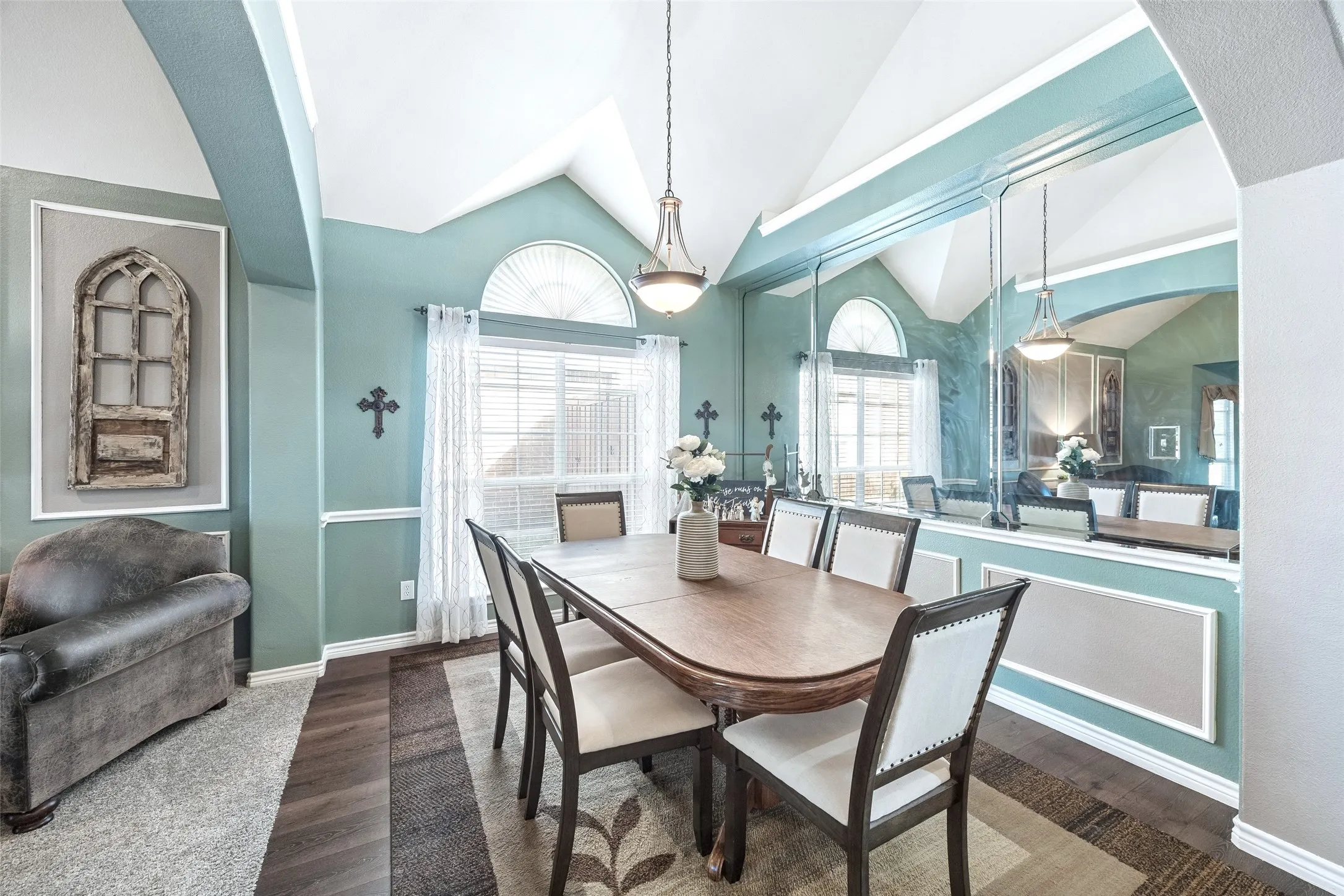Formal Dining with Dramatic Ceiling Lines — A vaulted ceiling and oversized arched transom window give the dining room considerably more volume than a typical enclosed dining space, while the large front-facing window brings in natural light.