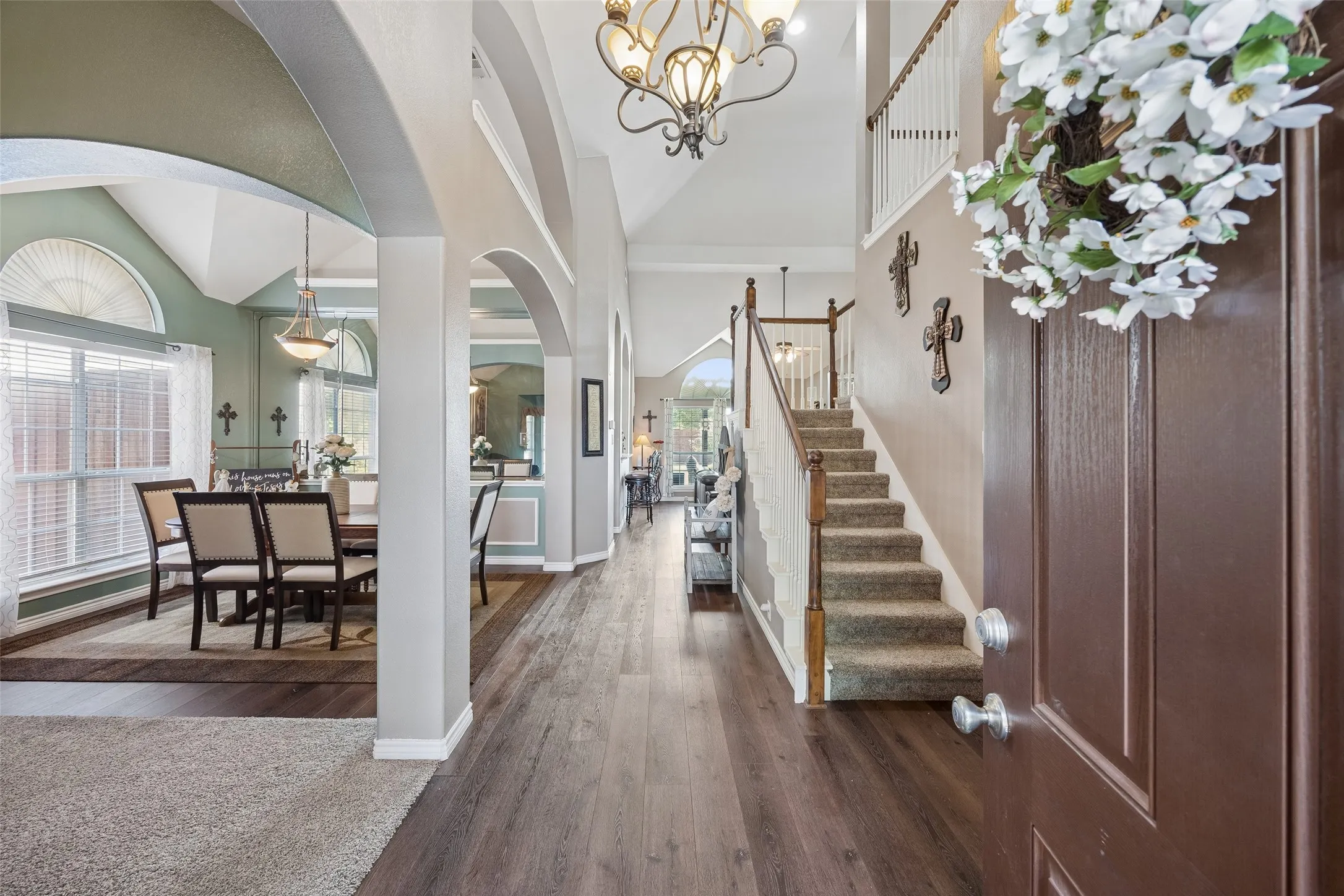 A Floor Plan That Opens Up Immediately — From the front door, the long central sightline reveals how the first floor connects, with the formal dining room to the left, staircase to the right, and family room visible beyond. Arched openings and tall ceilings keep the spaces visually connected.

