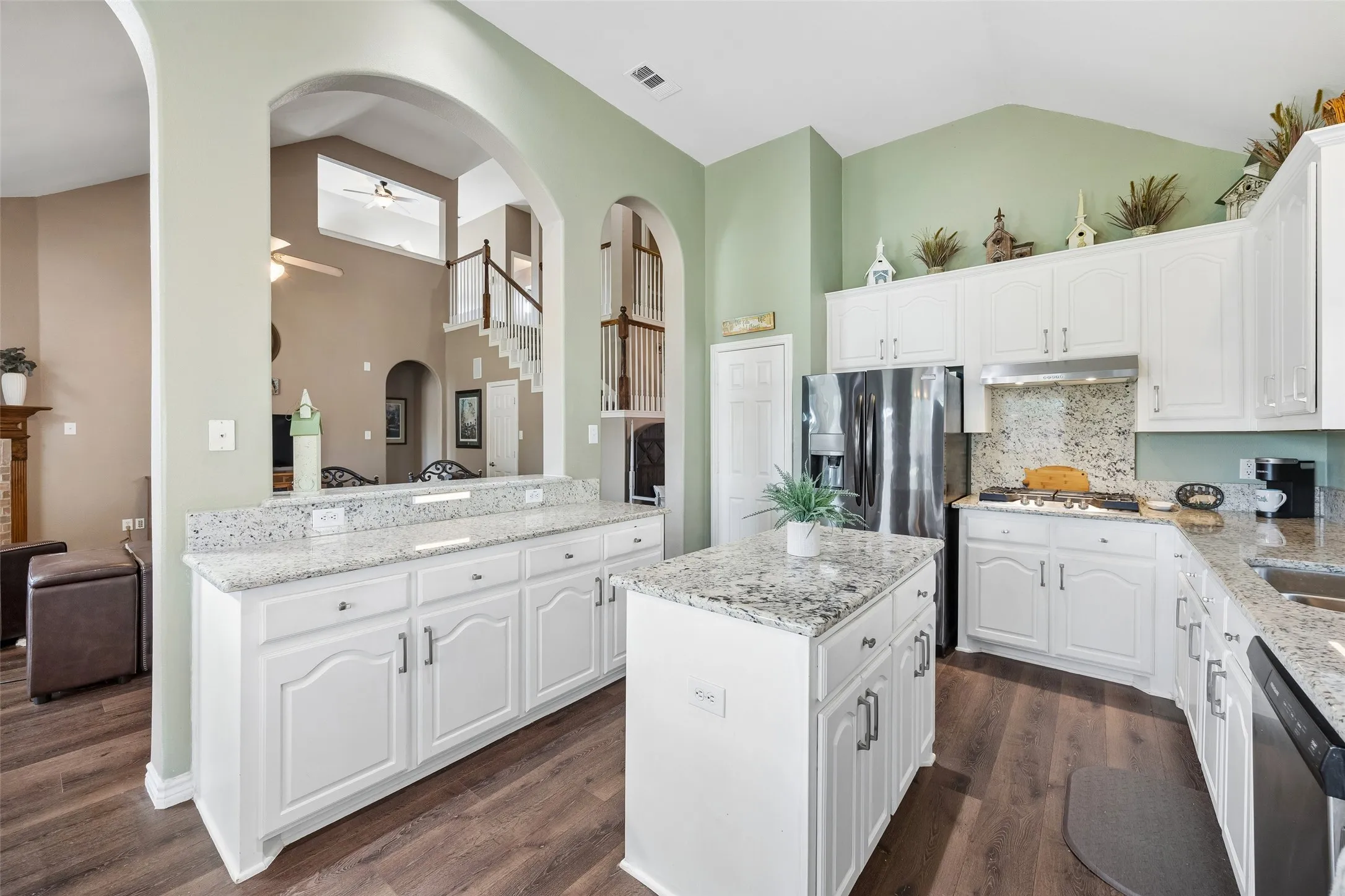 Central Island Keeps Prep Space Within Reach — The kitchen island creates a dedicated work surface in the center of the room, while perimeter counters, abundant cabinetry, and the nearby breakfast area support an efficient setup for everyday cooking and serving.