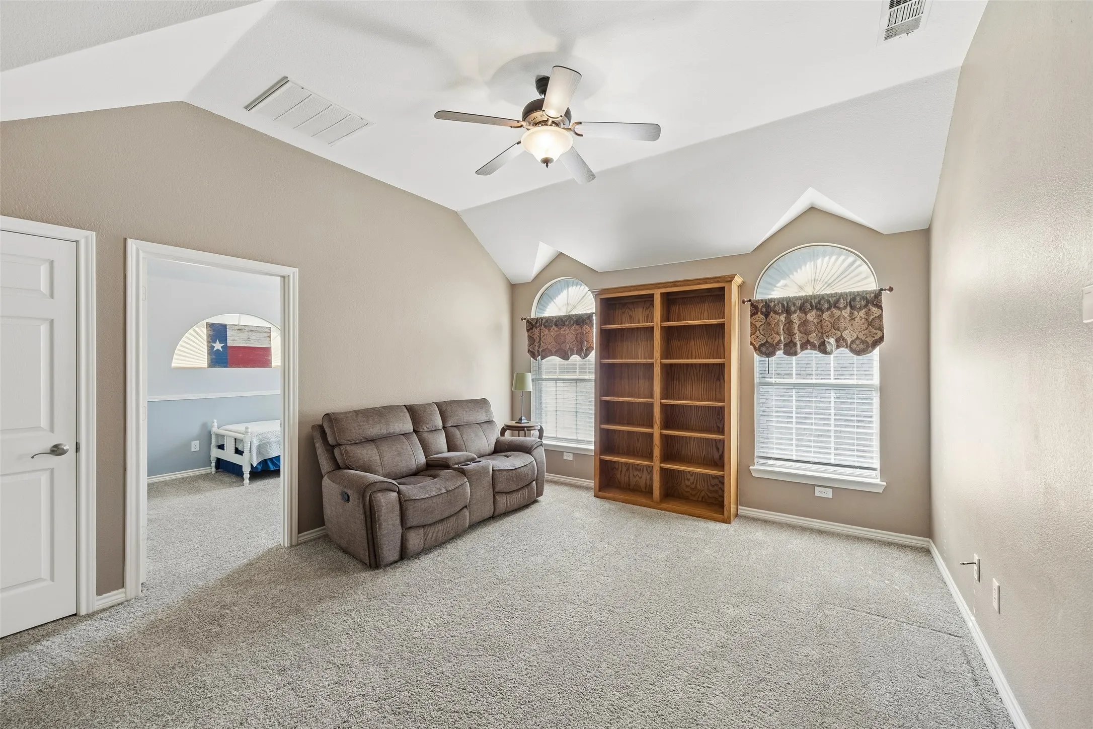 Upstairs Game Room Offers Real Flexibility — This generously sized second living area gives the home valuable space beyond the main-level family room. Vaulted ceiling lines, two arched windows, and an open connection to the upstairs landing make it well suited for games, media, hobbies, or a relaxed secondary gathering space.