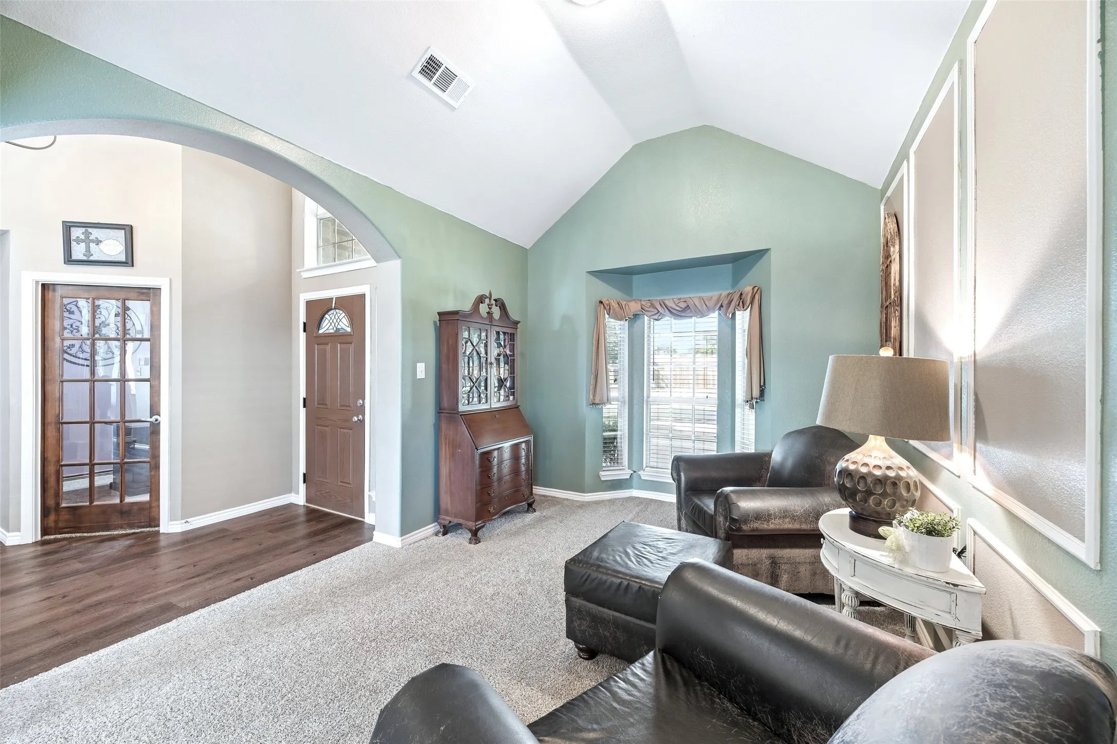 Front Living Room with a Vaulted Ceiling — This secondary living space gets architectural interest from its vaulted ceiling and deep bay window. Its position at the front of the home provides separation from the main family room for households that want more than one place to relax.