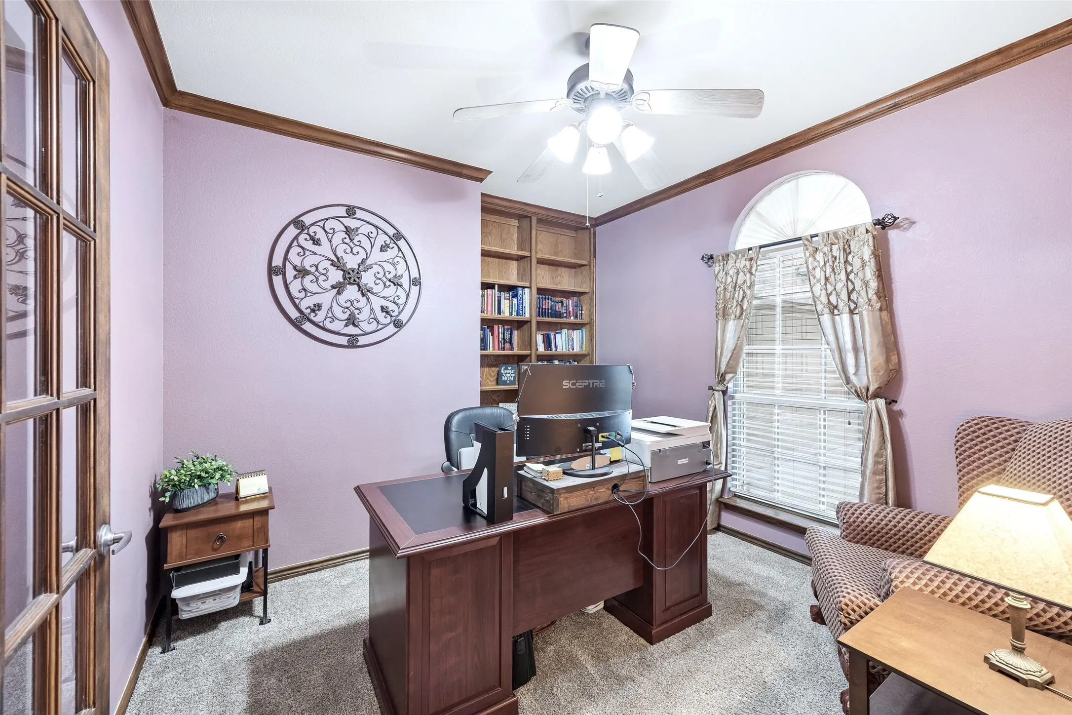 Private Office Just Off the Foyer — French doors separate the dedicated office from the entry, while built-in bookcases provide permanent storage and display space. The front-facing window and high ceiling make this a functional workspace without borrowing a bedroom.