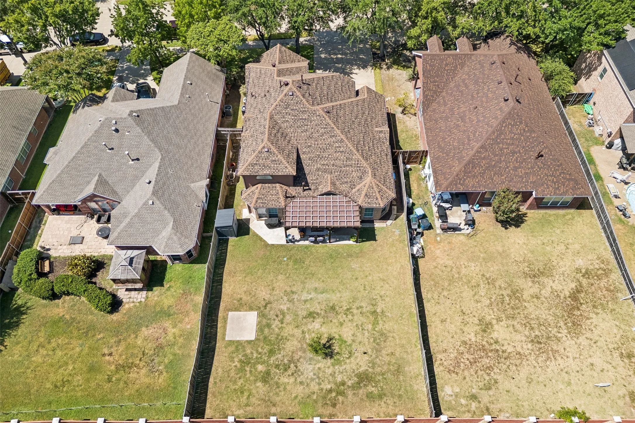 Aerial View of the Home and Homesite — This overhead perspective shows the home's substantial roofline, established front trees, fenced backyard, and placement within the surrounding neighborhood.
