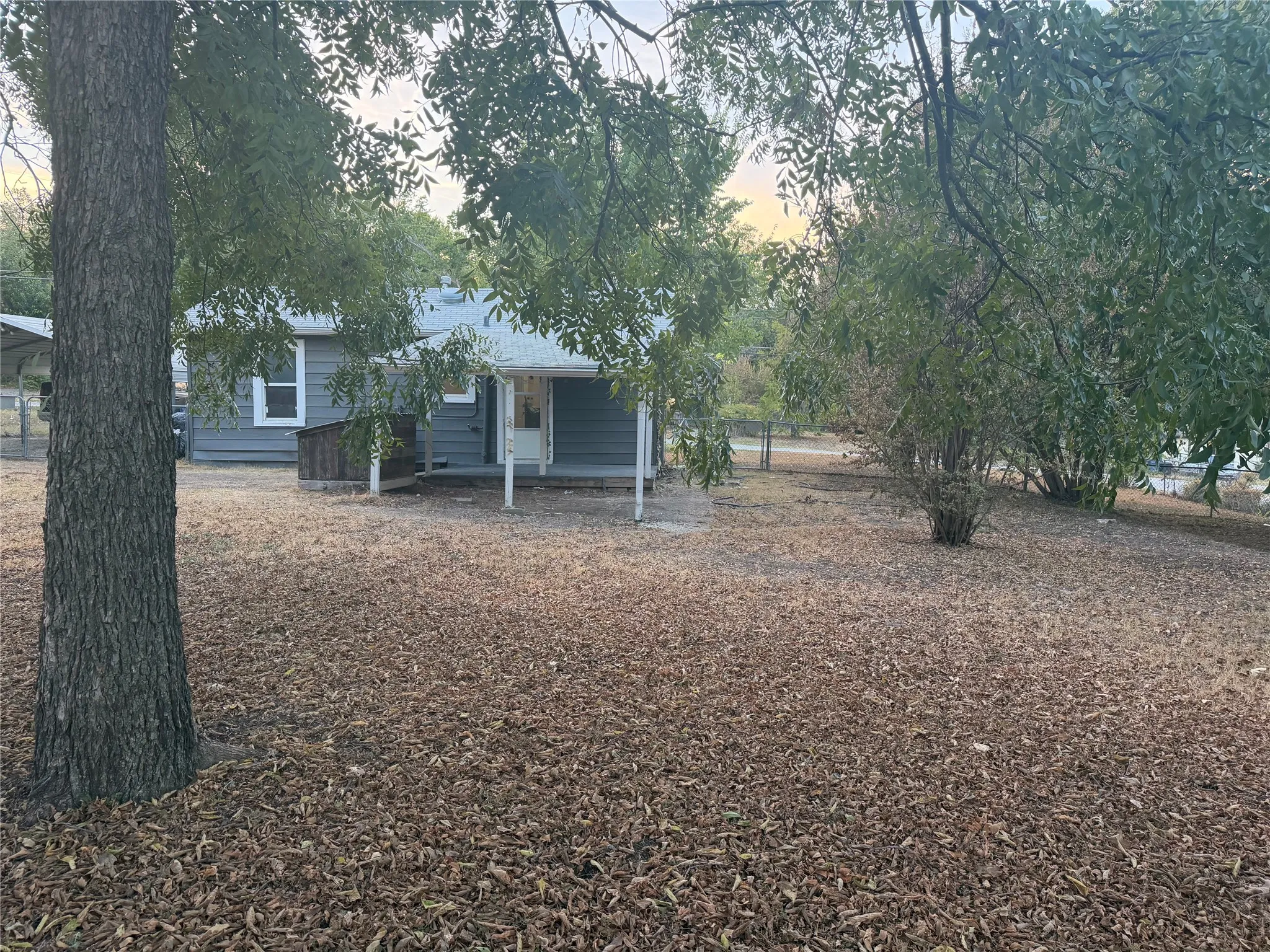 Residential structure with grey siding, white trim, and a covered porch with white support posts