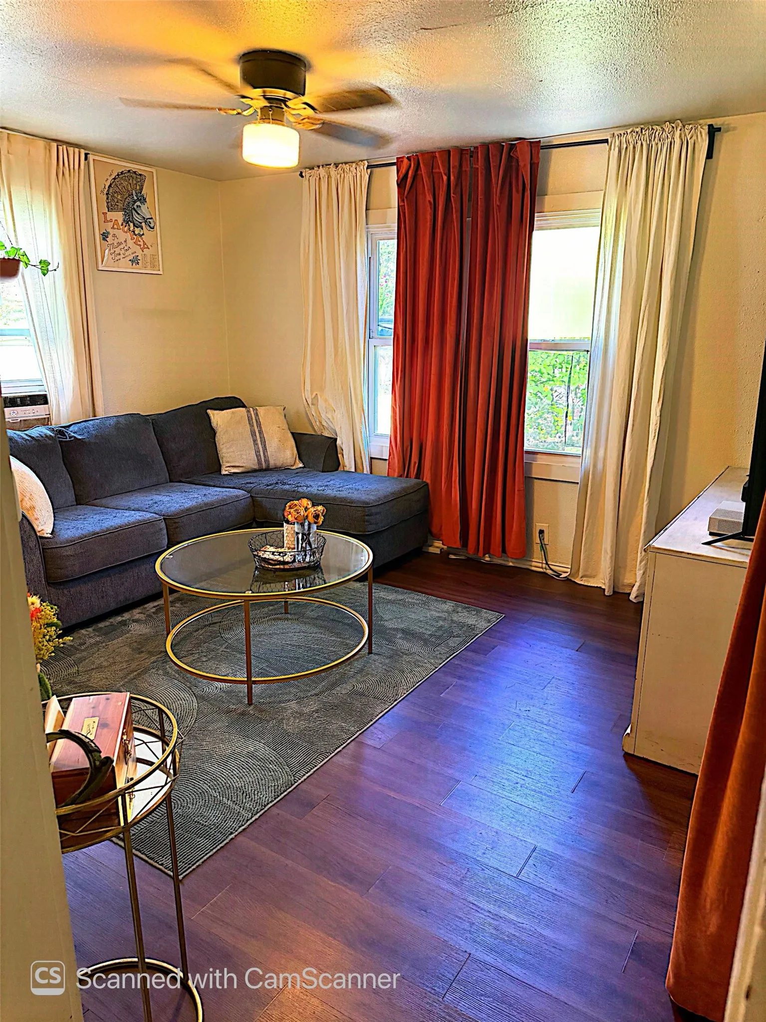 Living space with wood-finish flooring and multiple windows