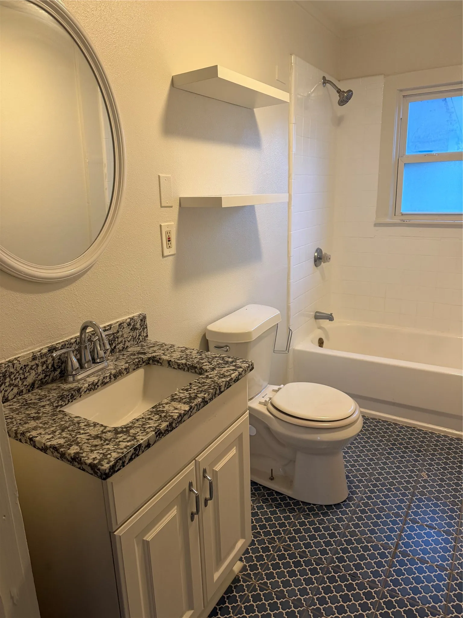 Bathroom featuring a white vanity with a dark speckled countertop, undermount sink, and polished chrome faucet